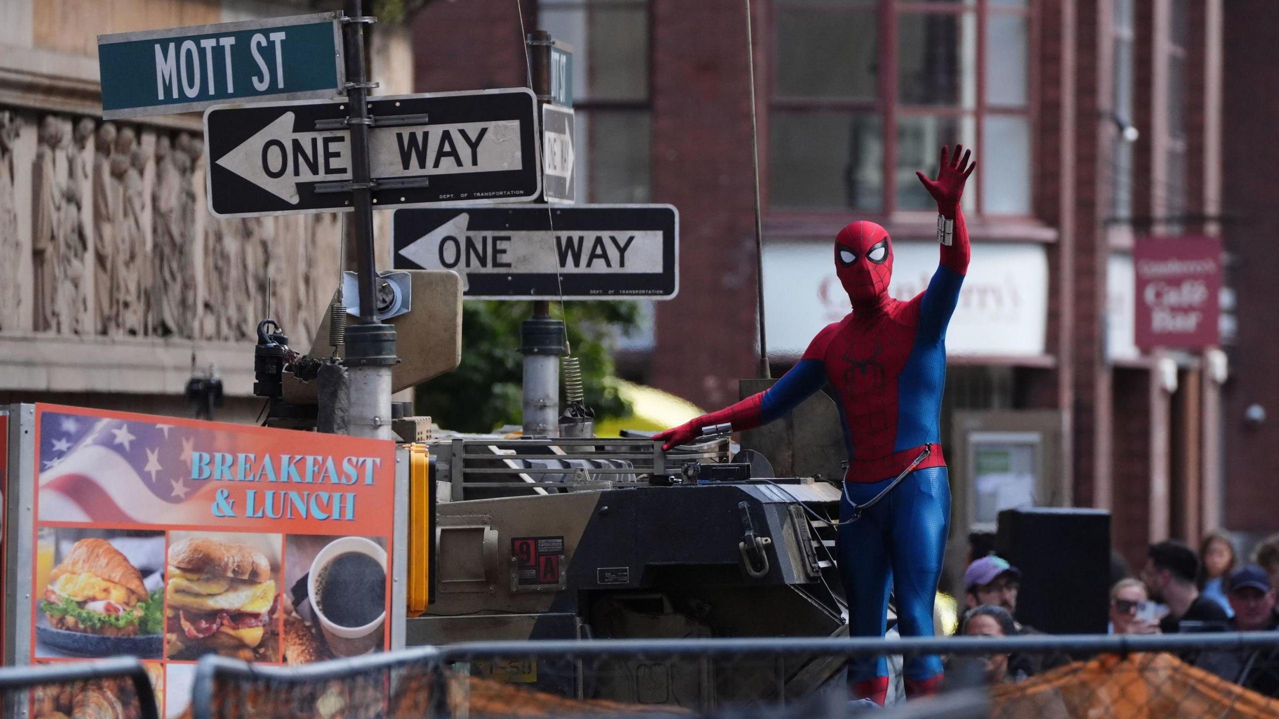 Spider-Man waves to fans during filming on Hutcheson Street in Glasgow