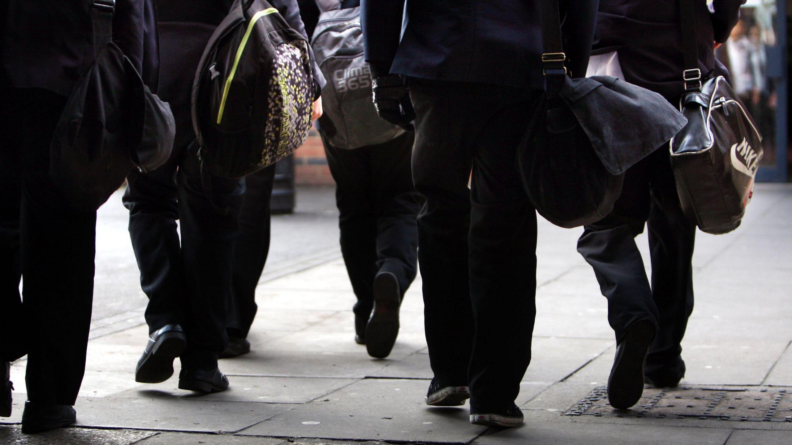 Children walking to school carrying bags