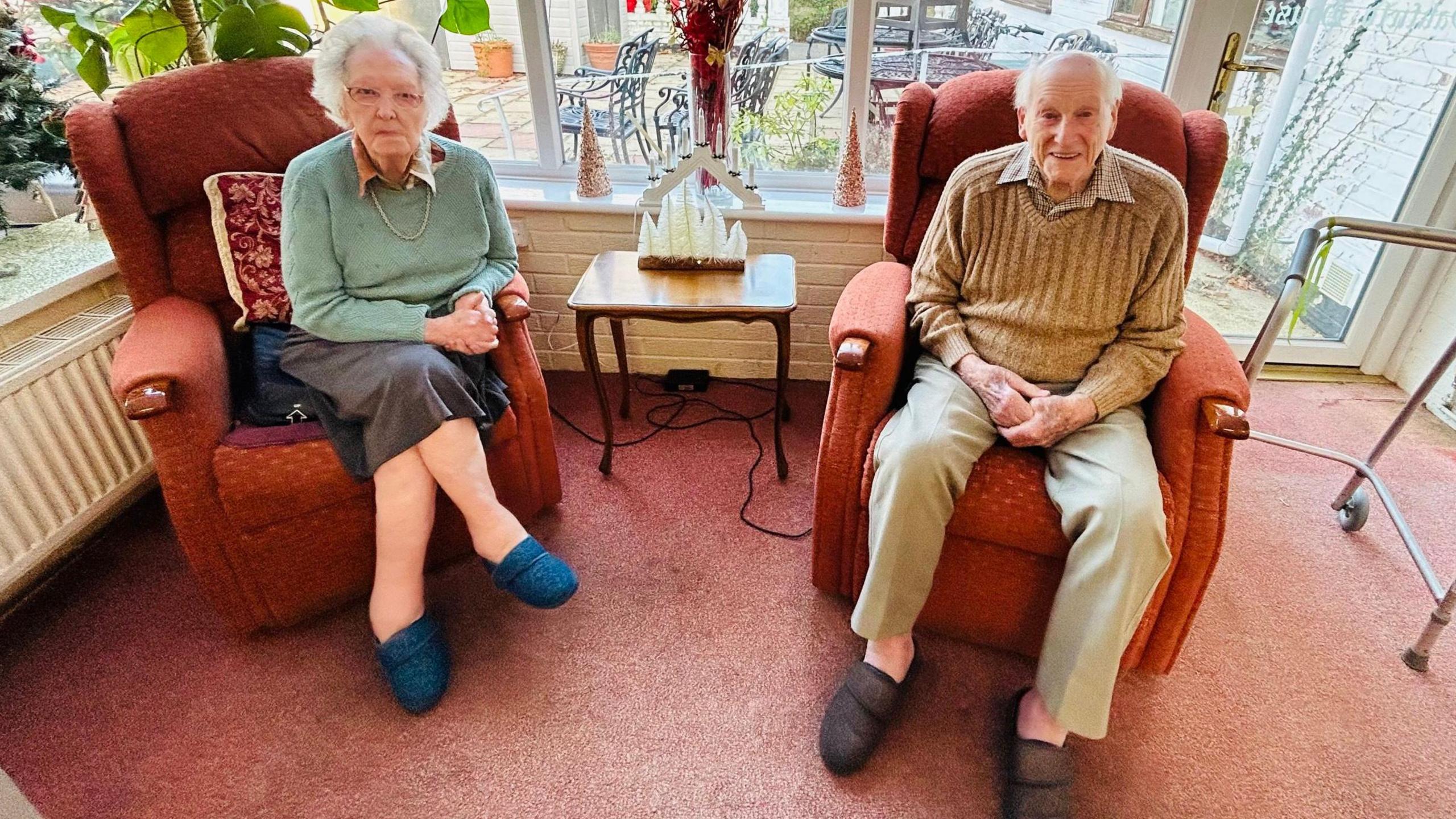 Dorothy and Tim Walter sitting in armchairs in their care home