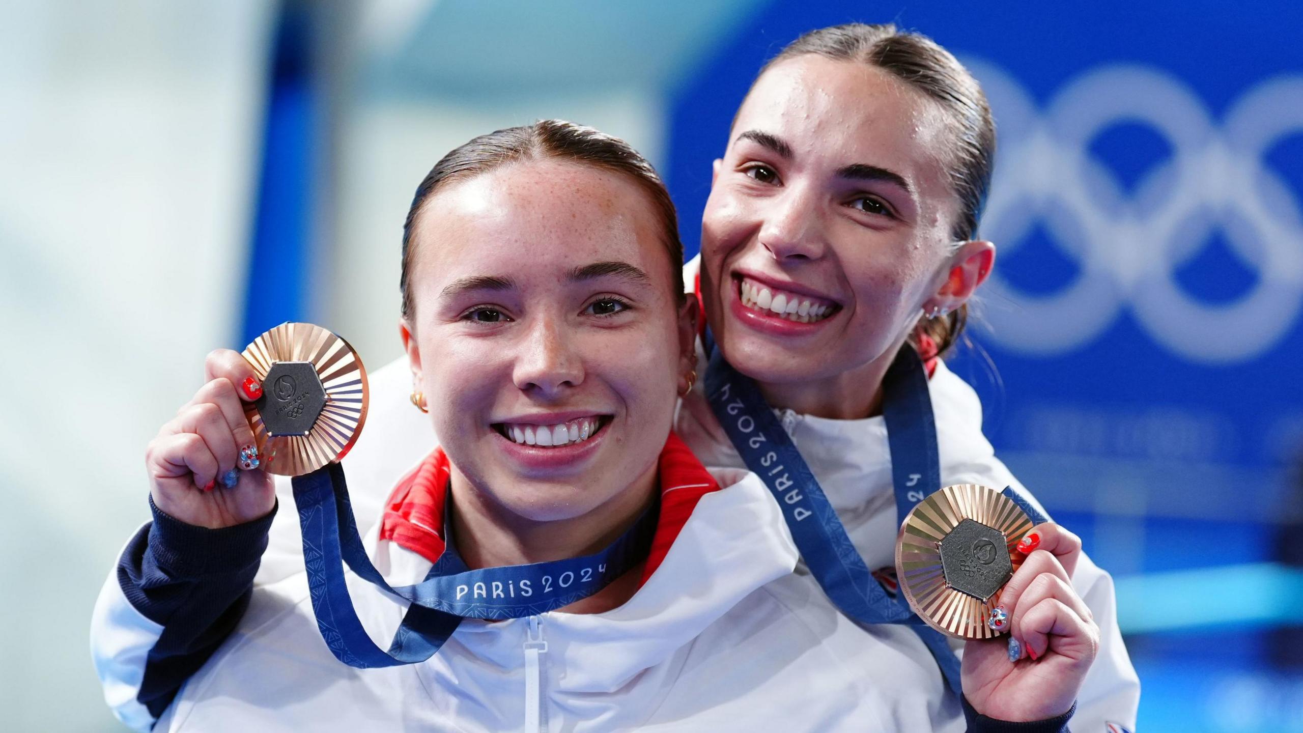 Divers Yasmin Harper and Scarlett Mew Jensen smiling with their bronze medals