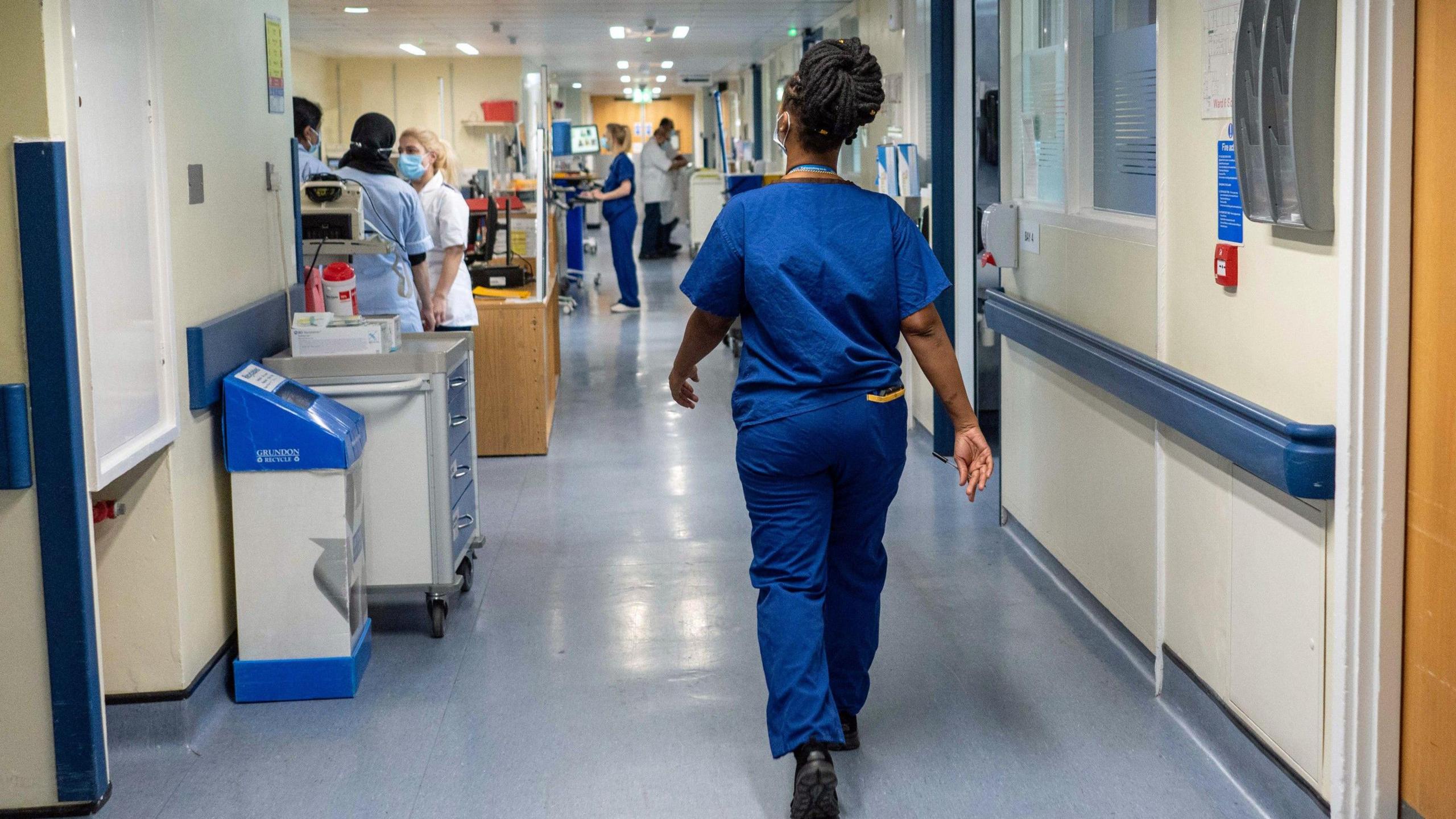 Nurse walking through hospital corridor