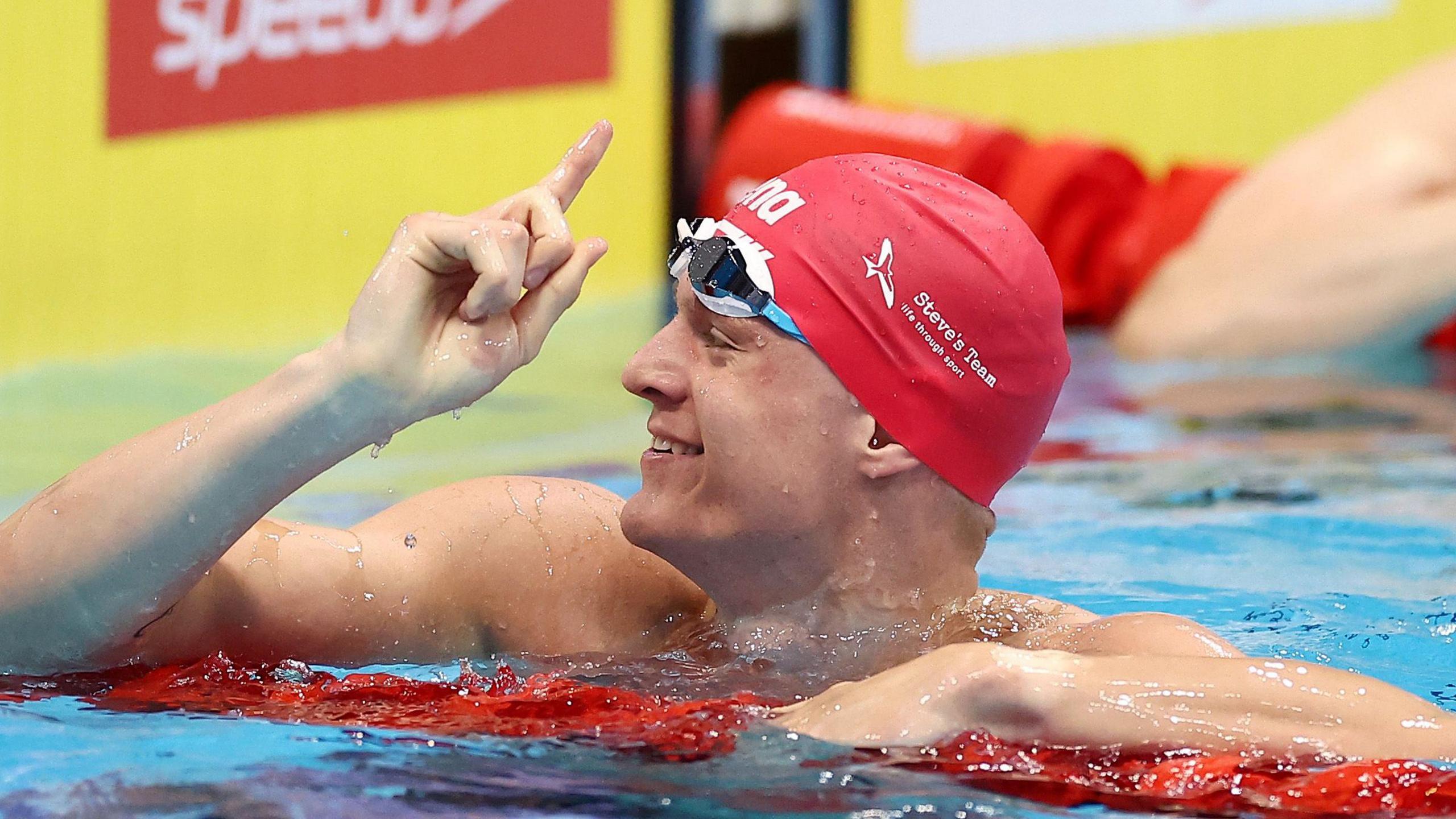 Ollie Morgan in the pool, celebrating winning a race