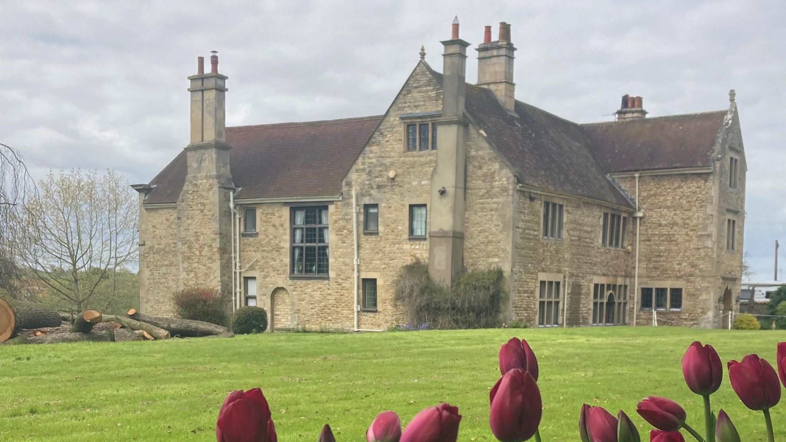 A image of Fulbeck Manor, a stately home, with tulips in the foreground.