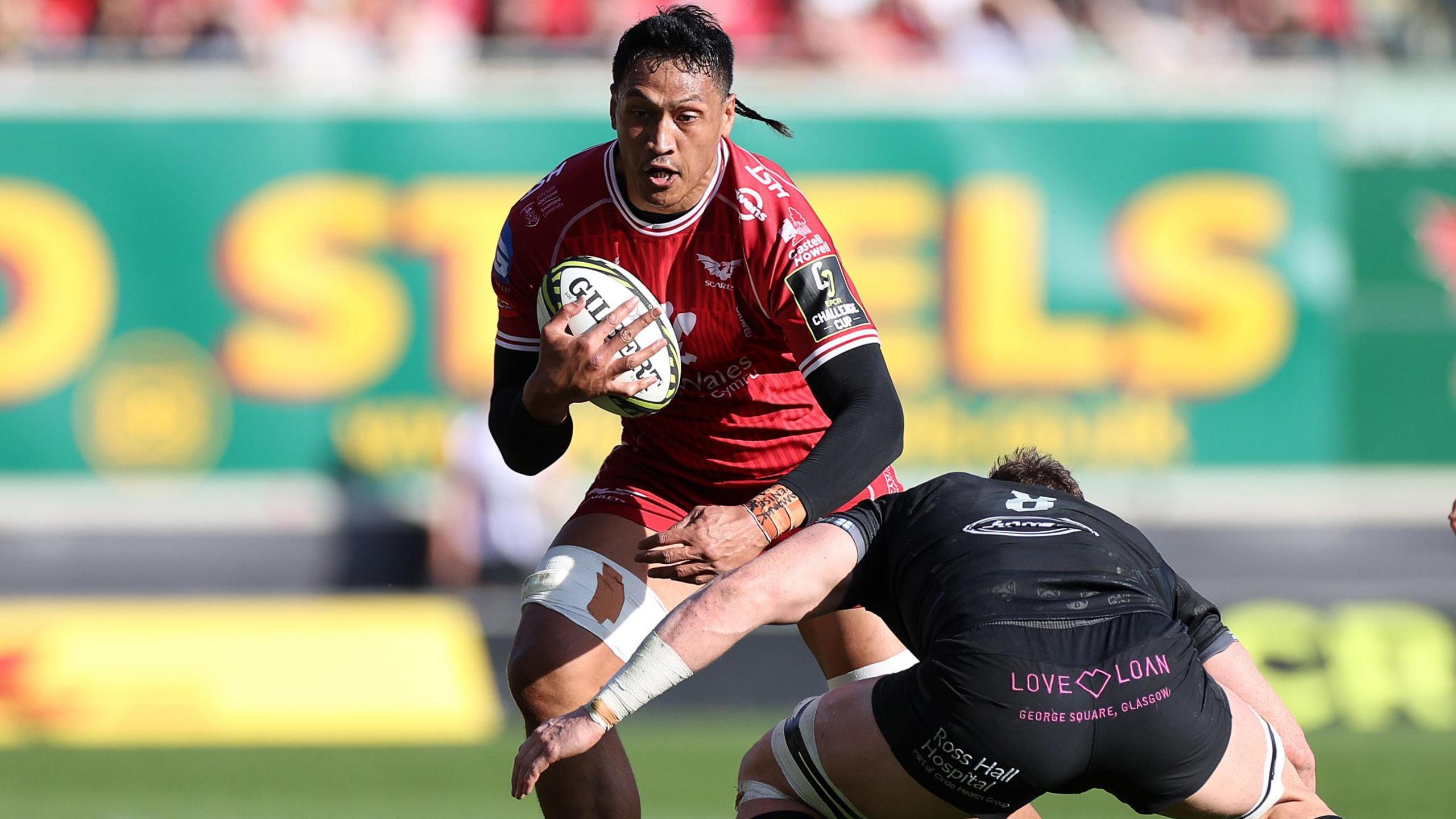 Sam Lousi carries the ball into a tackle