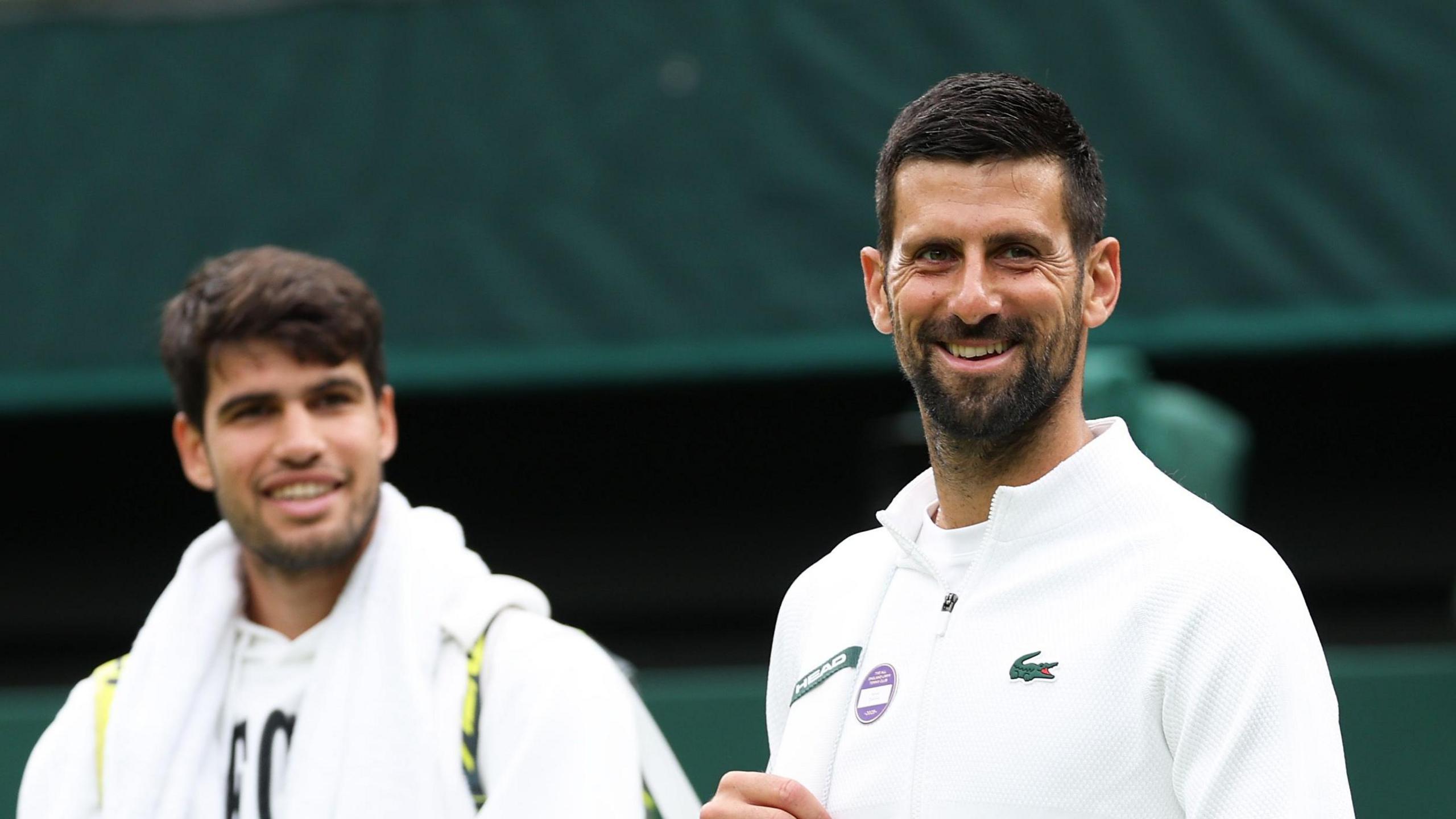 Carlos Alcaraz and Novak Djokovic walk out to practise at Wimbledon