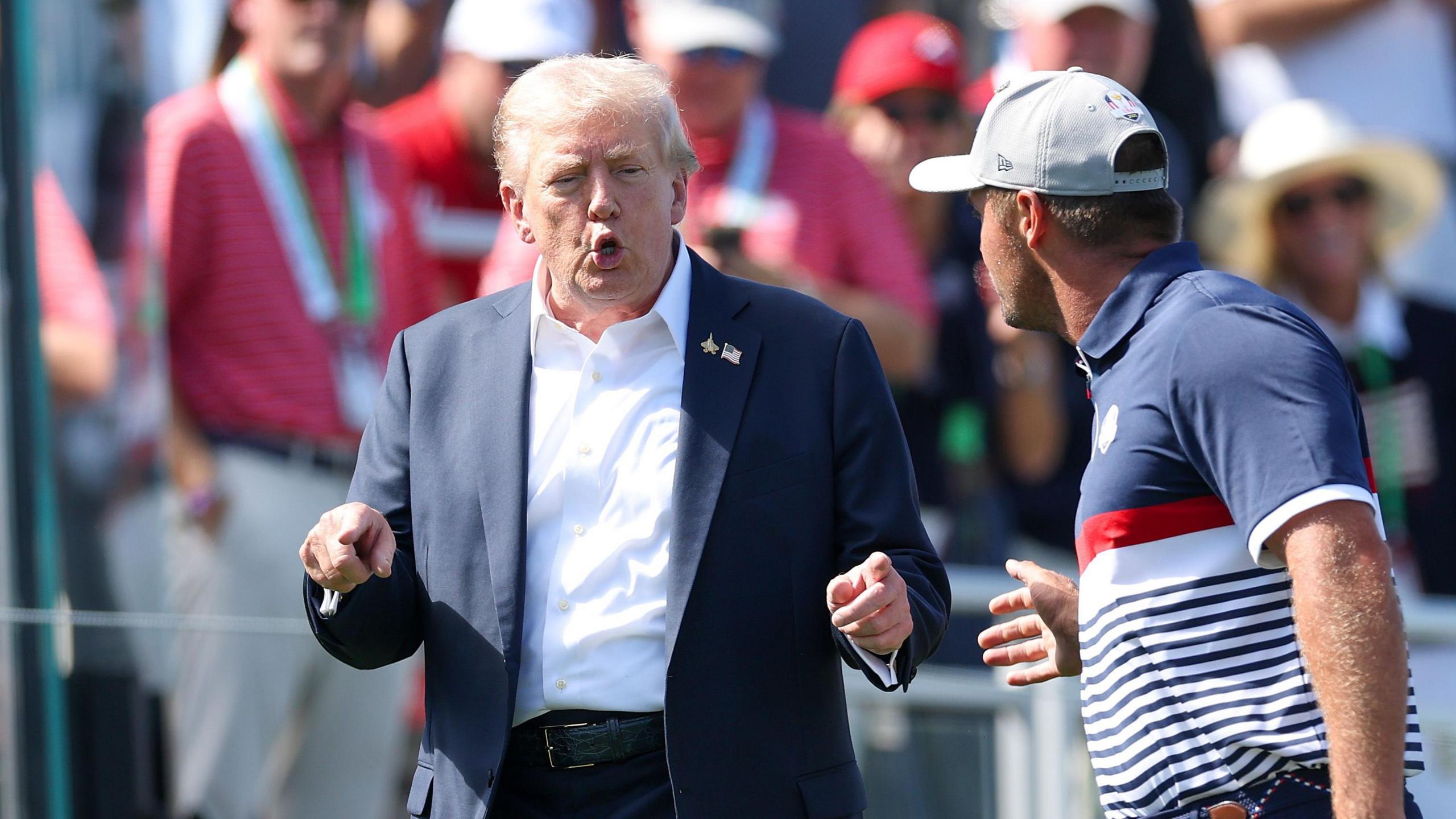 Donald Trump looks animated while in conversation with Bryson DeChambeau at Bethpage Black