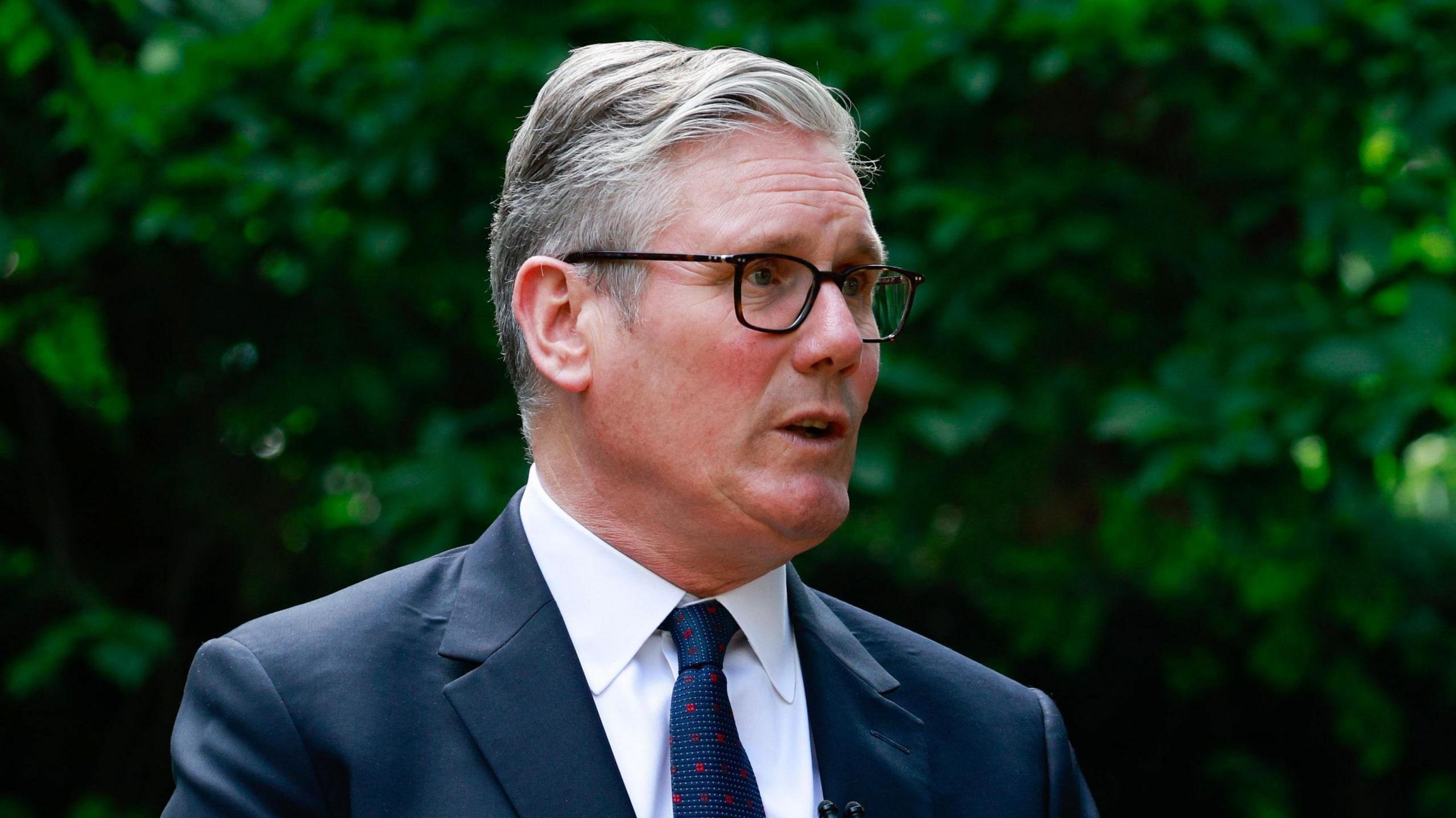 Keir Starmer wearing a suit, standing in the Downing Street garden