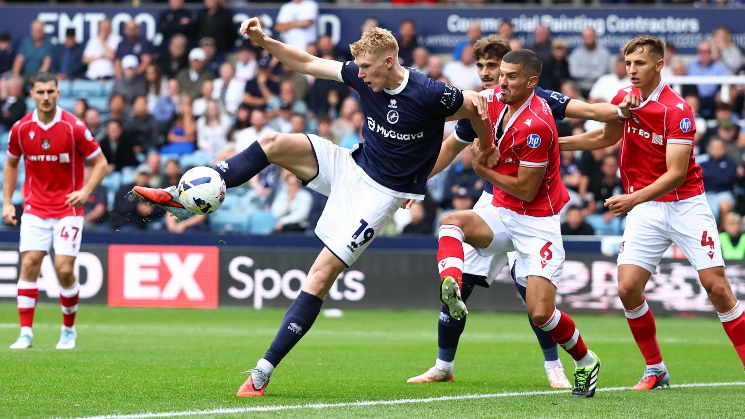 Millwall striker Josh Coburn controls the ball while surrounded by Wrexham players