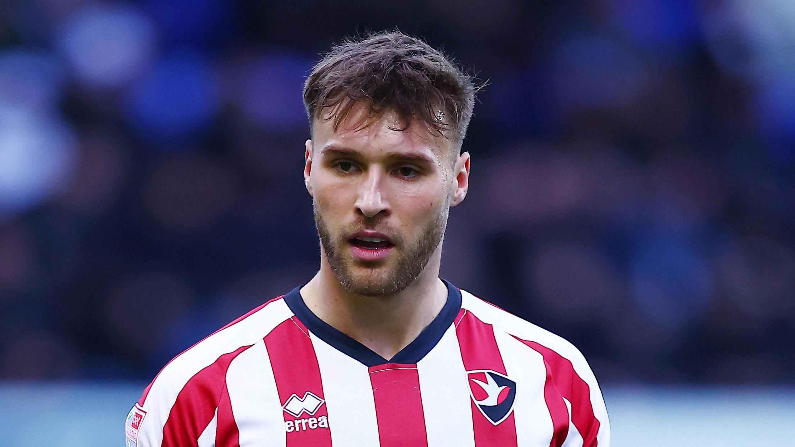 Sam Sherring wearing the red-and-white striped home kit of Cheltenham Town 