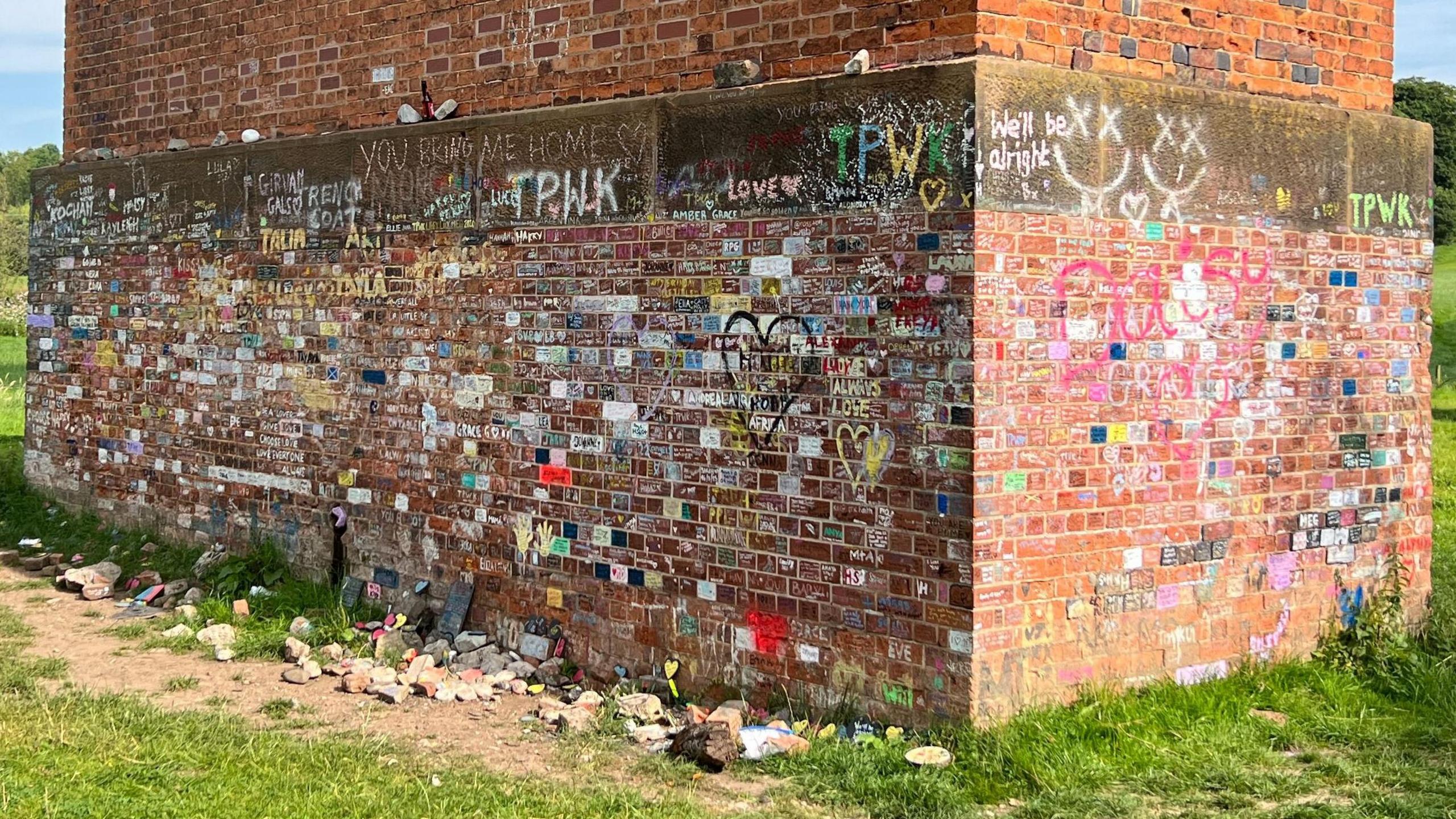 The brickwork of Twemlow Viaduct daubed in brightly coloured graffiti  