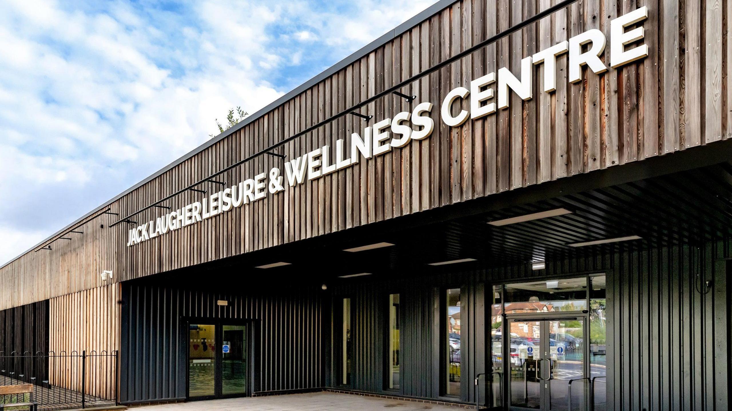 The entrance to the Jack Laugher Leisure & Wellness Centre - a large, wooden-clad building.