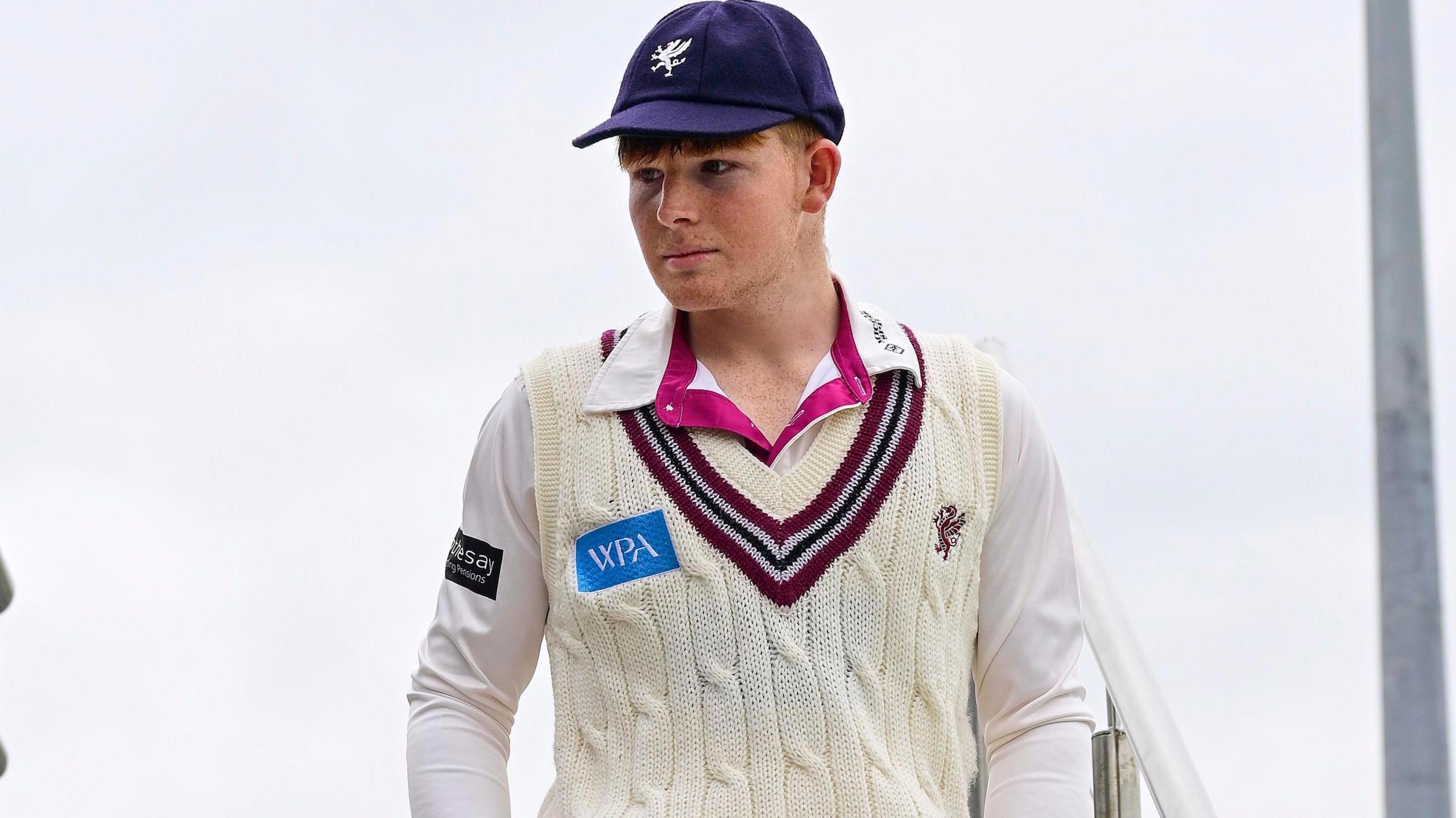 Thomas Rew wearing Somerset cricket whites walking down the steps at the County Ground as he makes his first-class debut