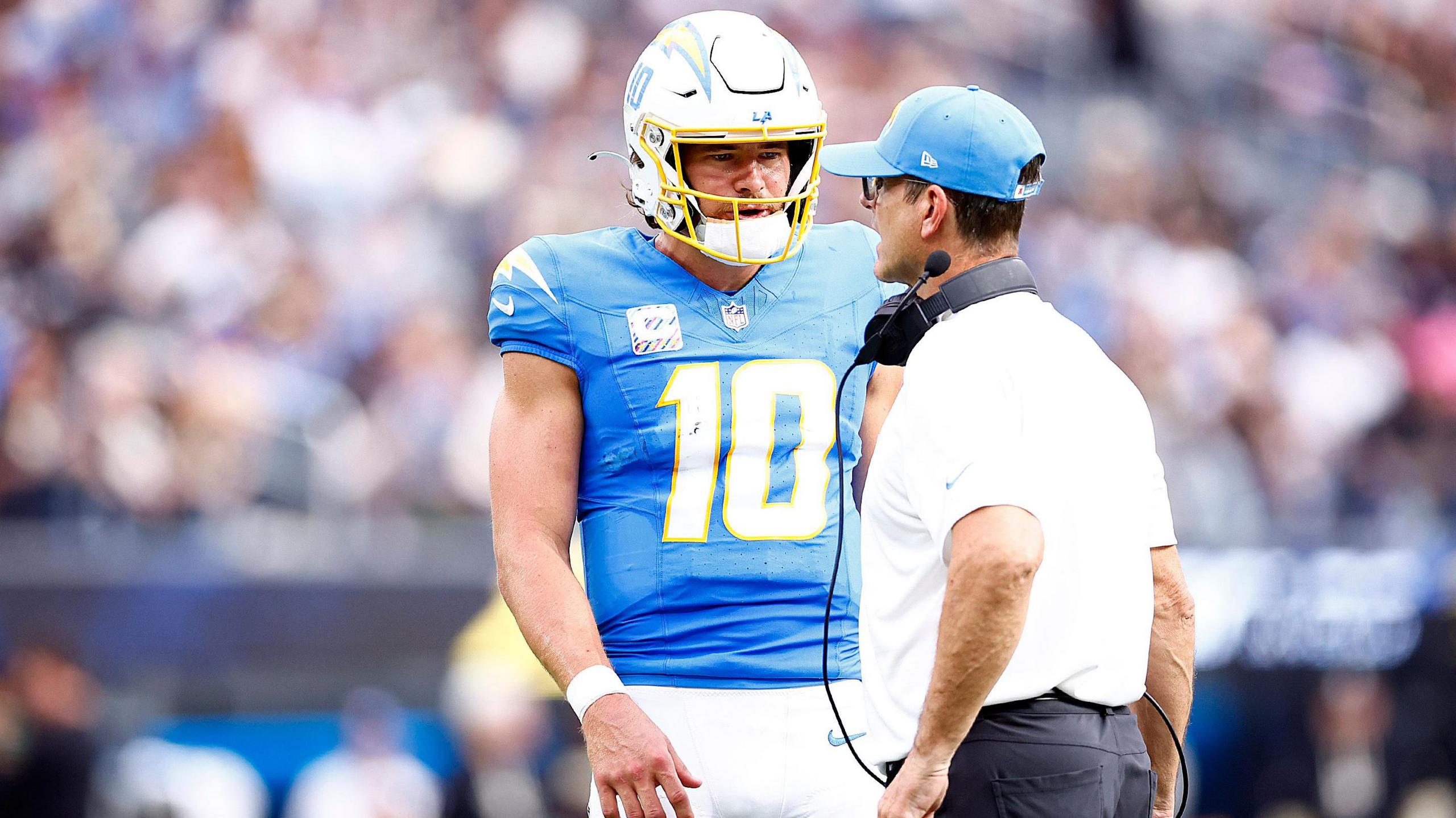 Los Angeles Chargers quarterback Justin Herbert and head coach Jim Harbaugh in conversation