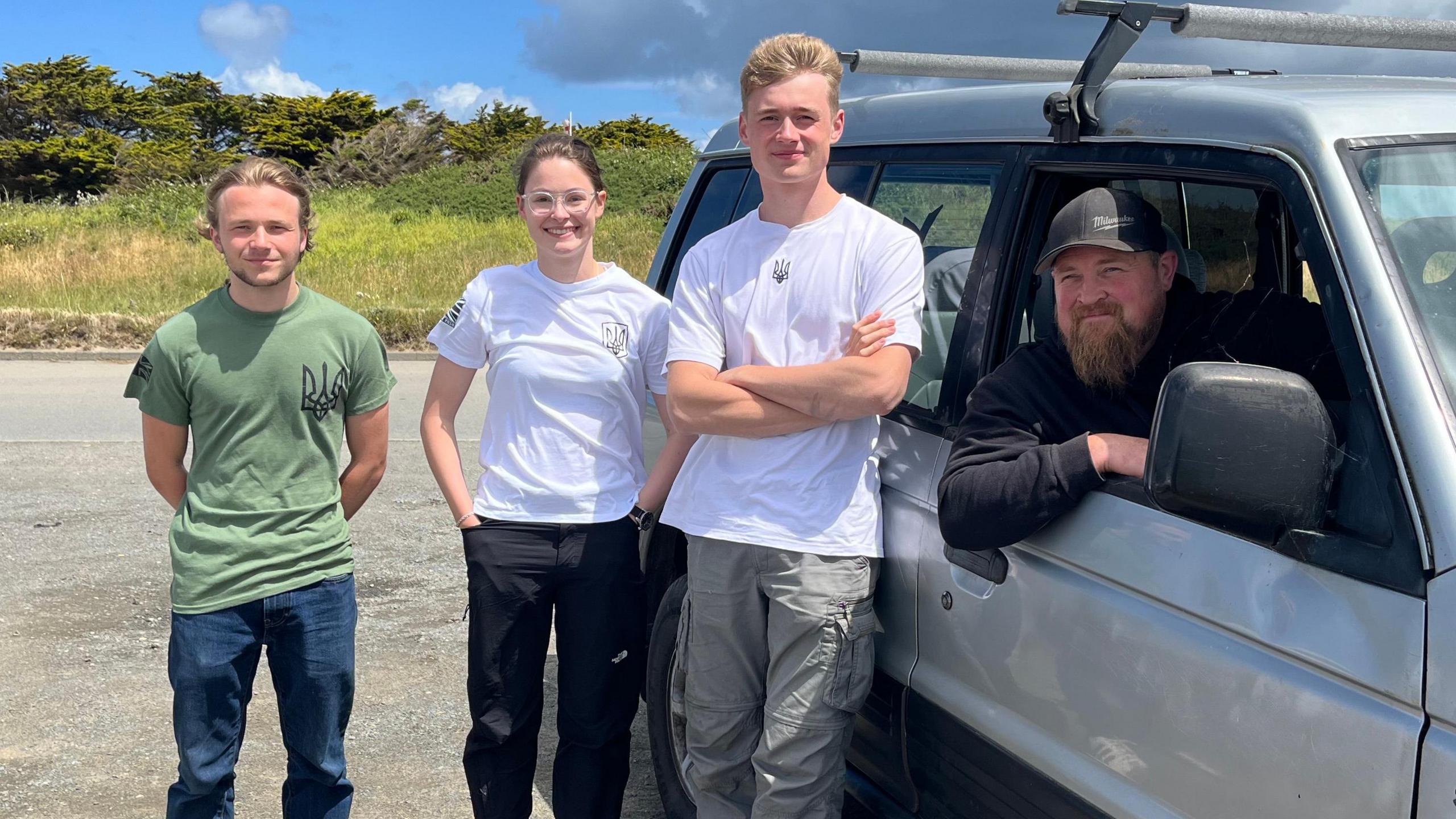 Emile, Daisy and Fergus standing beside the car with Craig inside