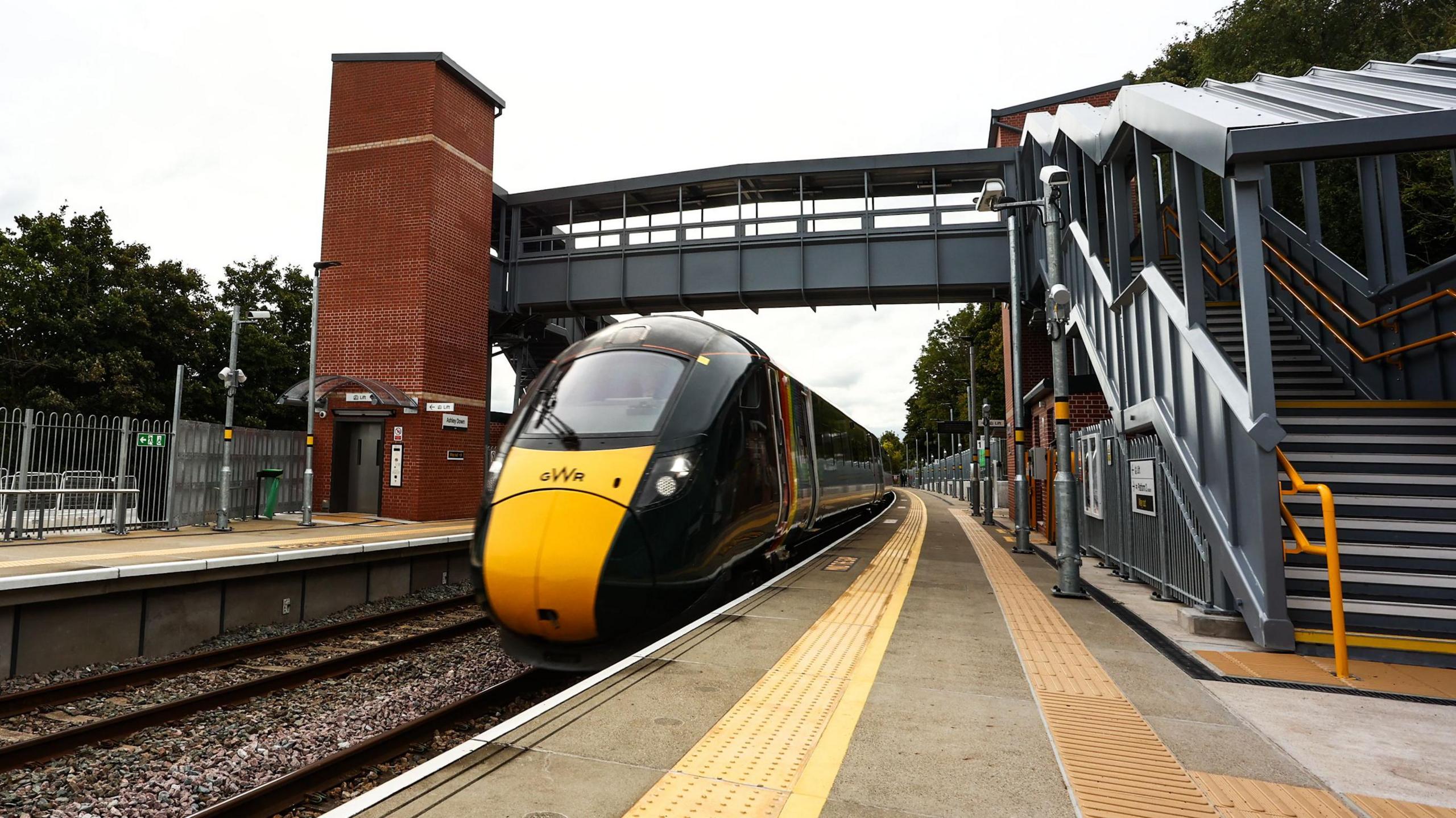 A GWR train standing at the platform of the new Ashley Hill station. The pedestrian walkway over the tracks and the new platforms are also in shot