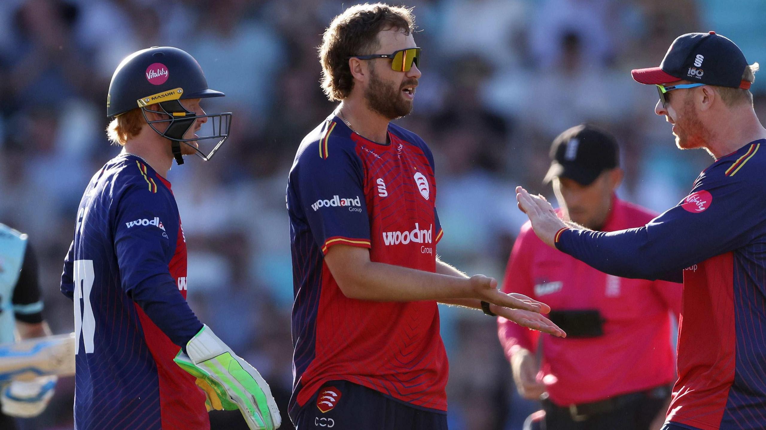 Matt Critchley, wearing Essex's red and blue shirt, celebrates taking a wicket