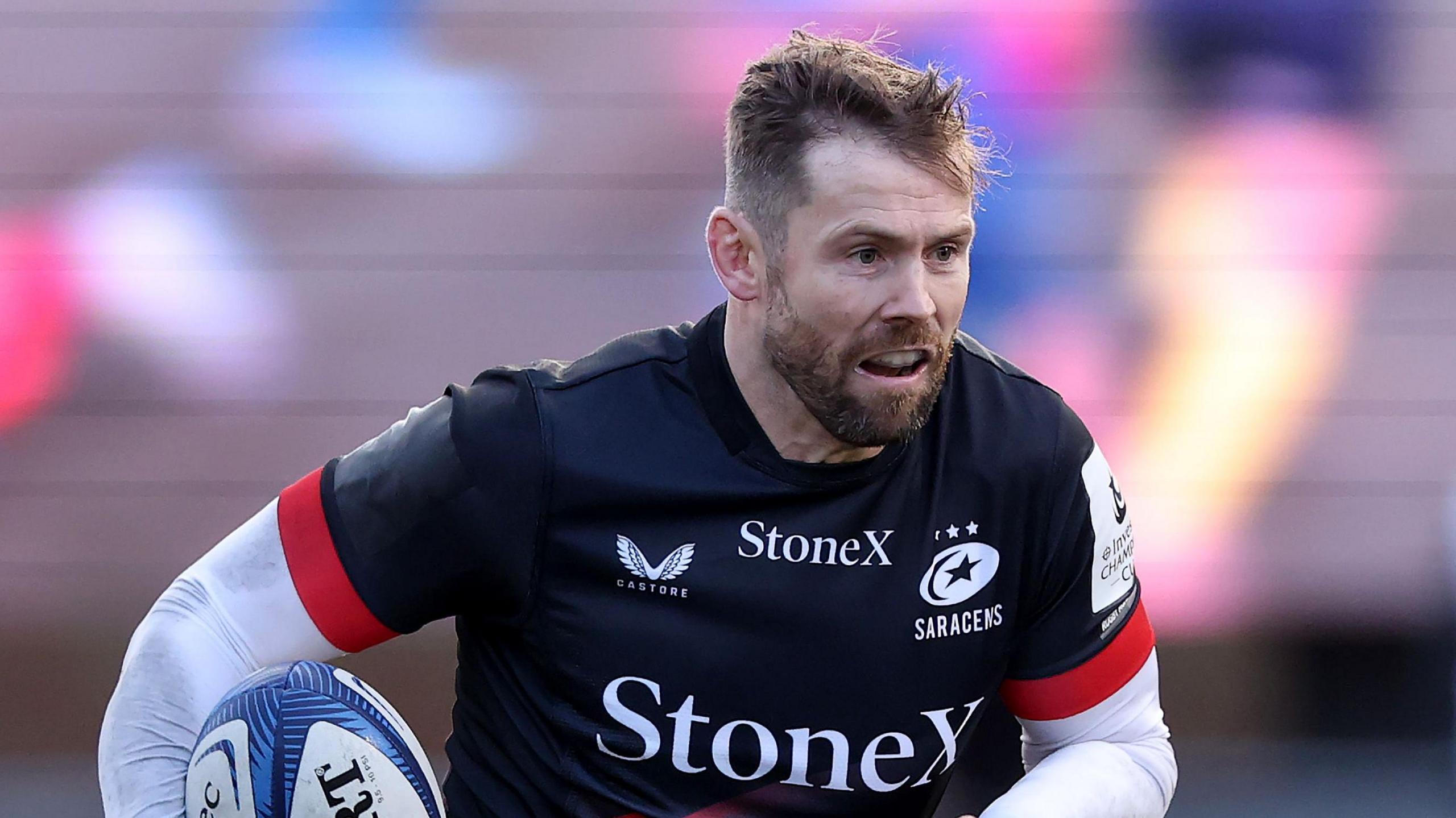Elliot Daly running with the ball under his right arm during a game for Saracens