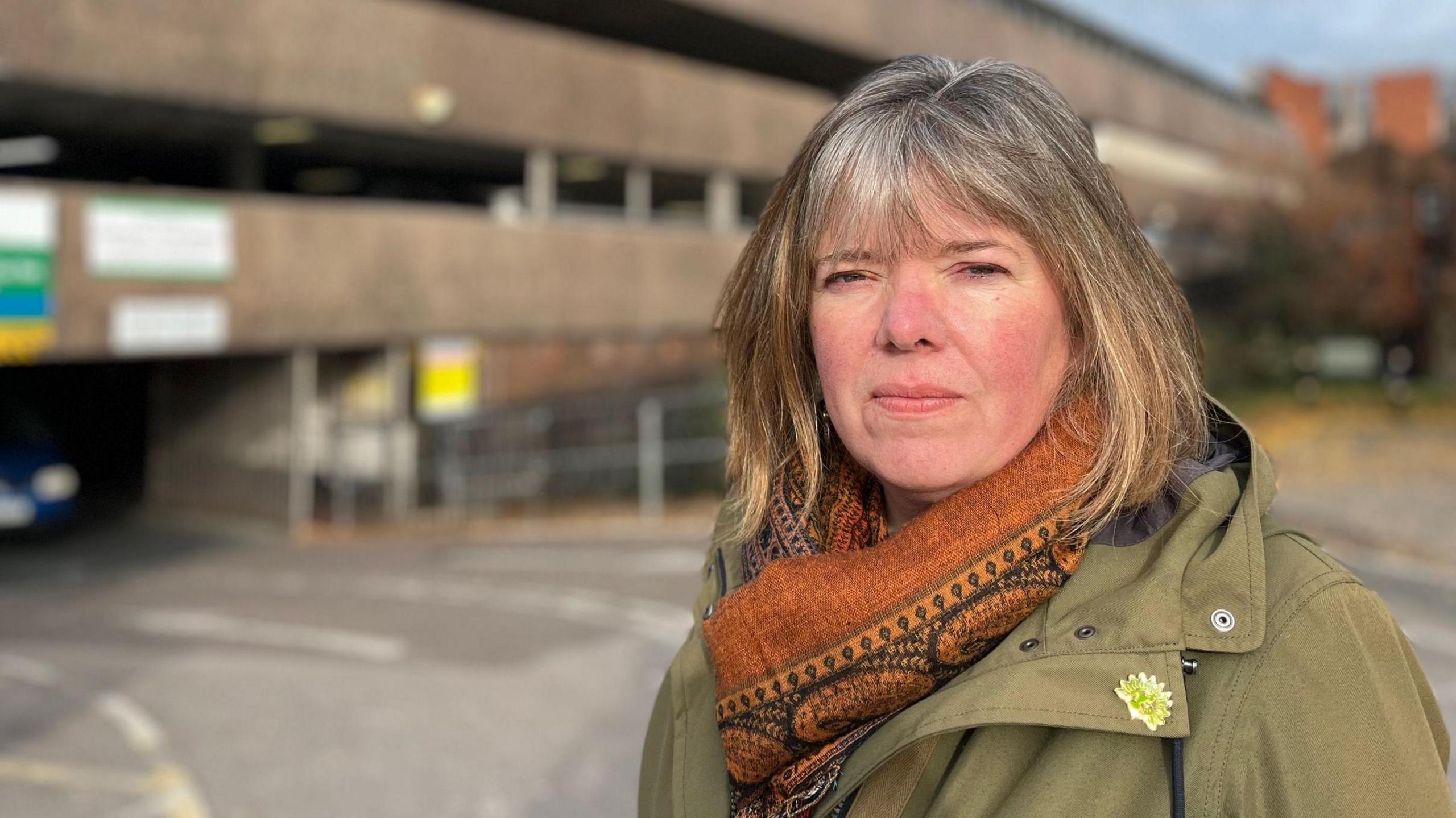 Diana Moore, leader of the Green Party on Exeter City Council, wearing a green coat and a rust-coloured patterned scarf