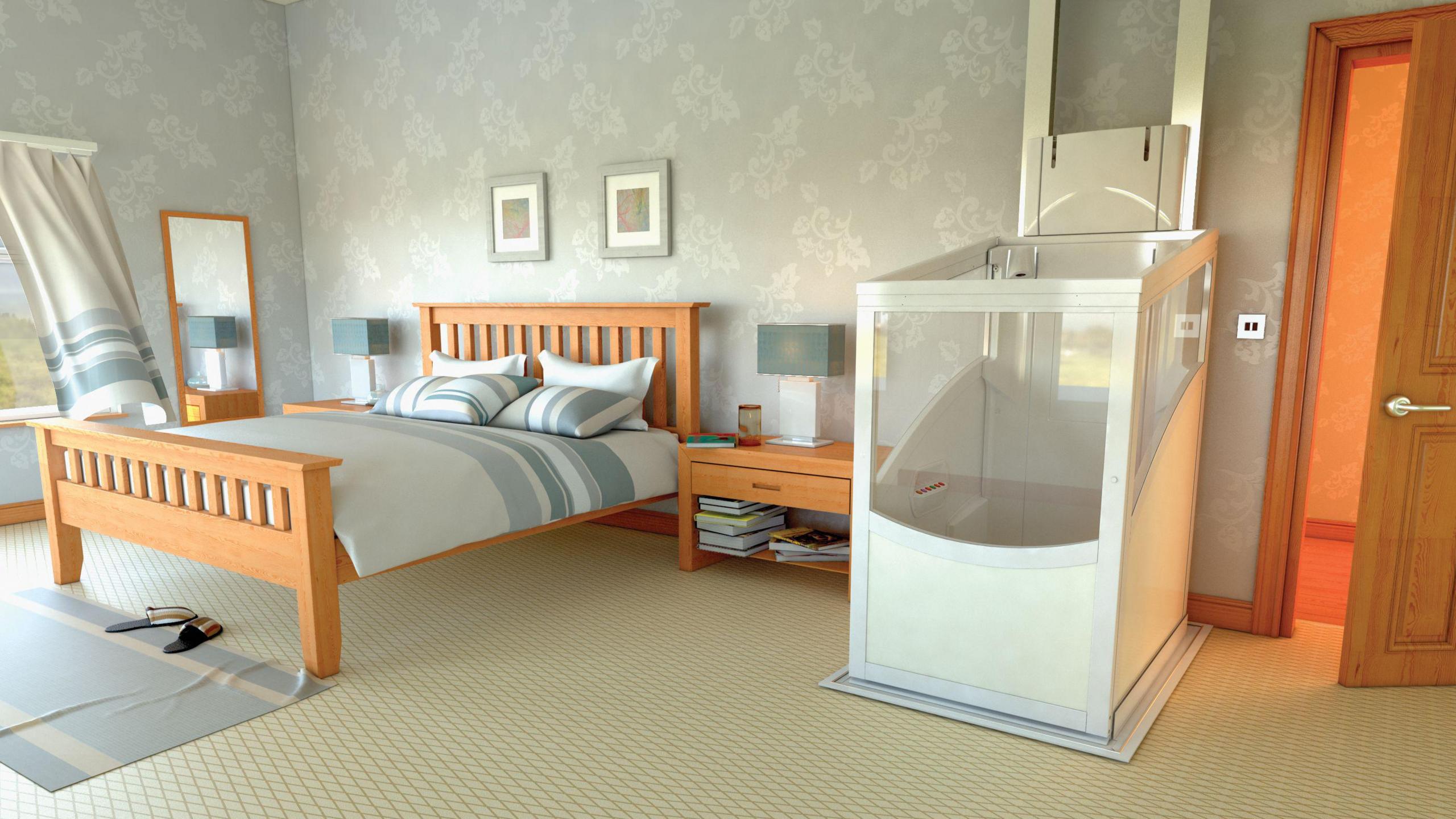 A bedroom with a grey colour scheme. A mat lies in front of the bed with slippers on it. To the left of the bed is a lift. It is an enclosed rectangular lift. 