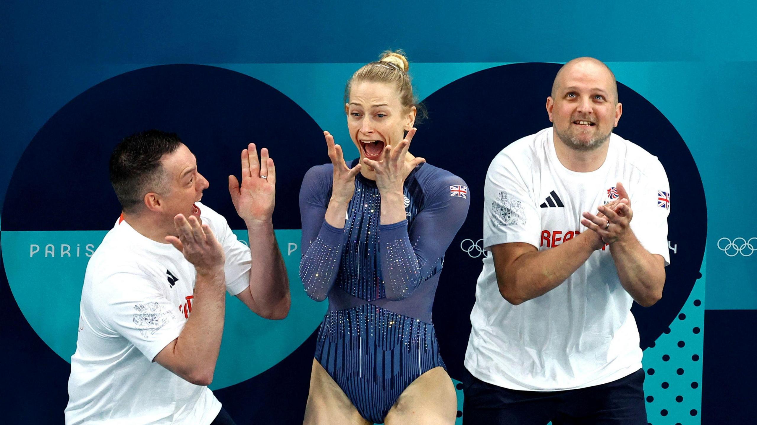 Bryony Page of Britain celebrates with her coaches after hearing her result.