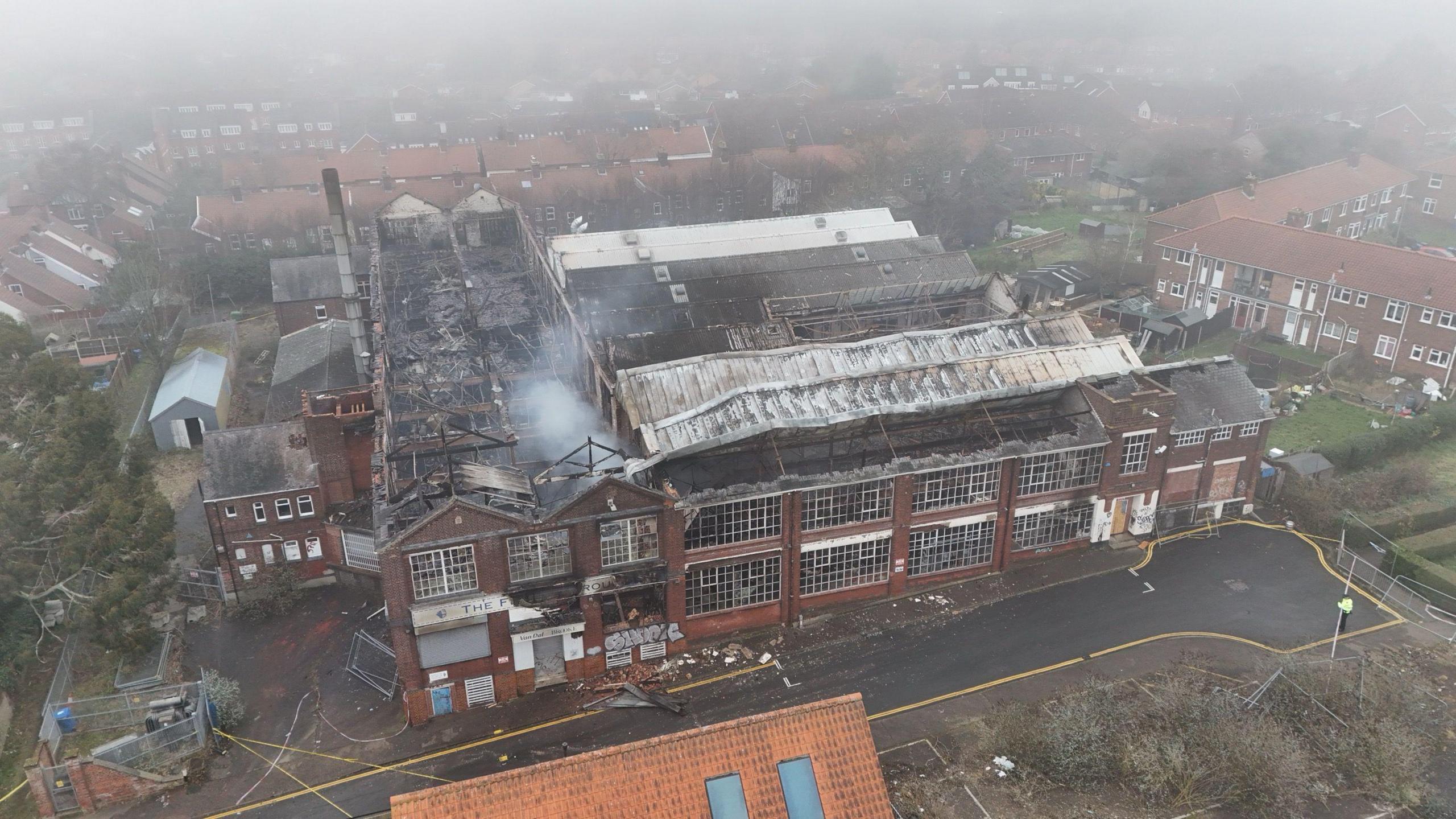 Smoke coming off of the derelict factory which was on fire. It is a large building with hundreds of window pains. The picture is taken from above.