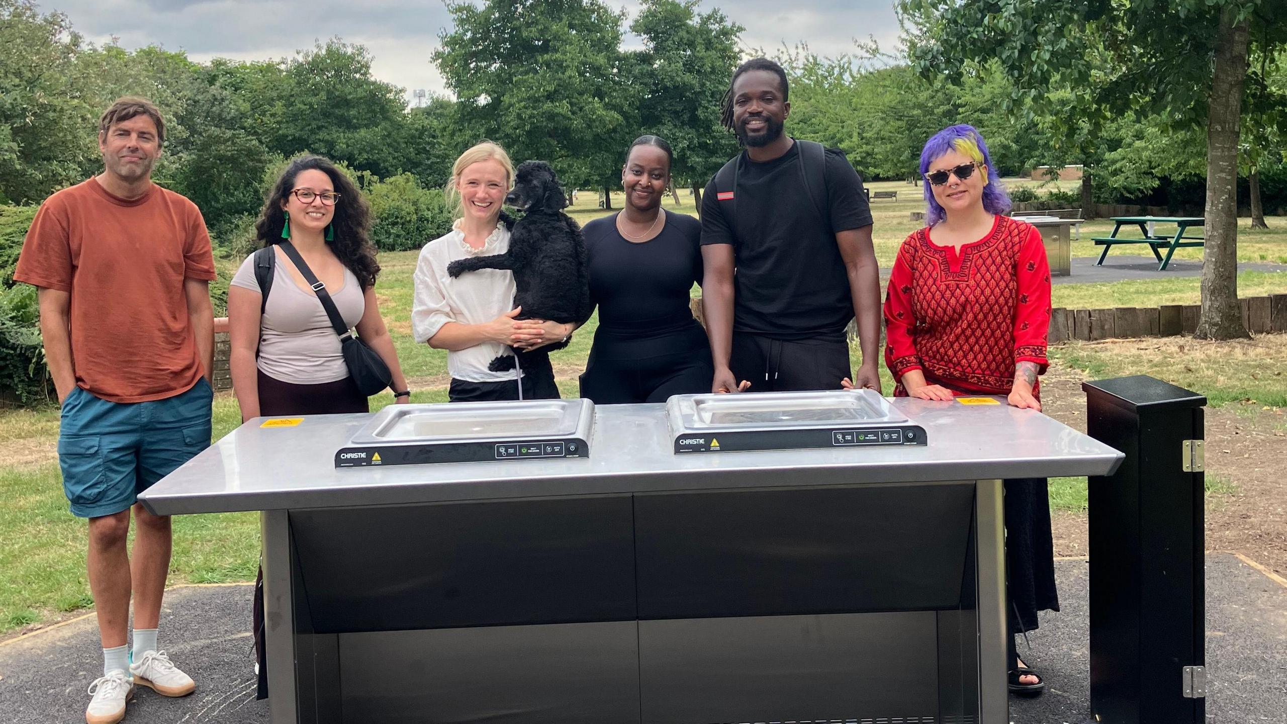 Councillors and community representatives stand around the new hotplates in Burgess Park 