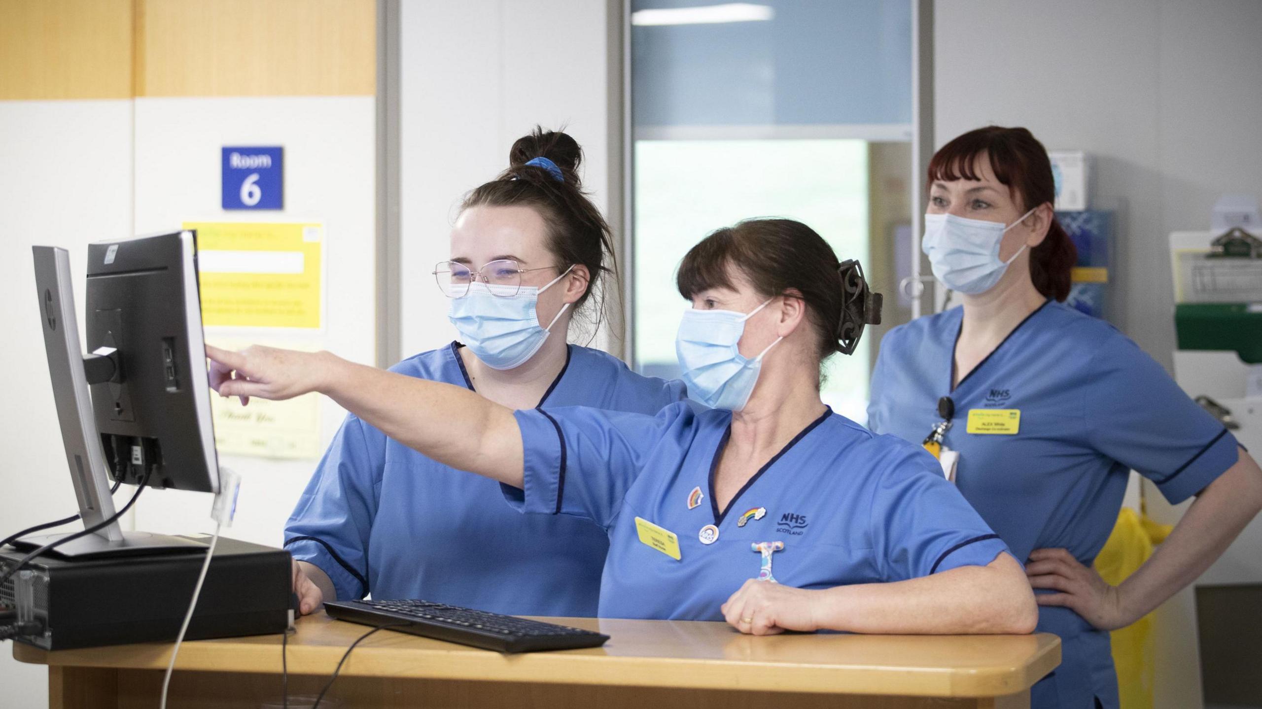 NHS staff wearing blue tunics