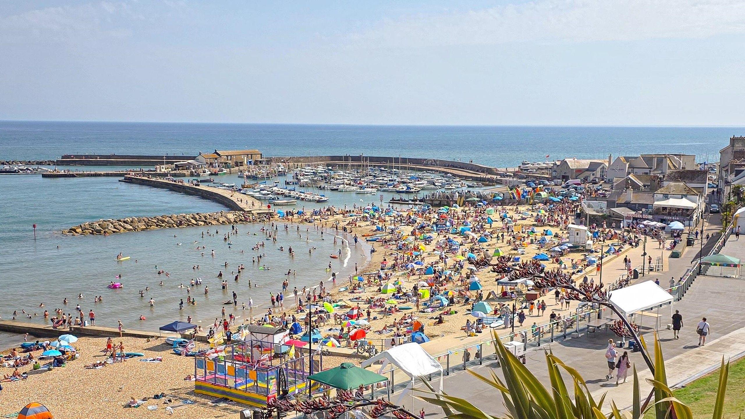 A photo of people on a beach in Lyme Regis during the last heatwave