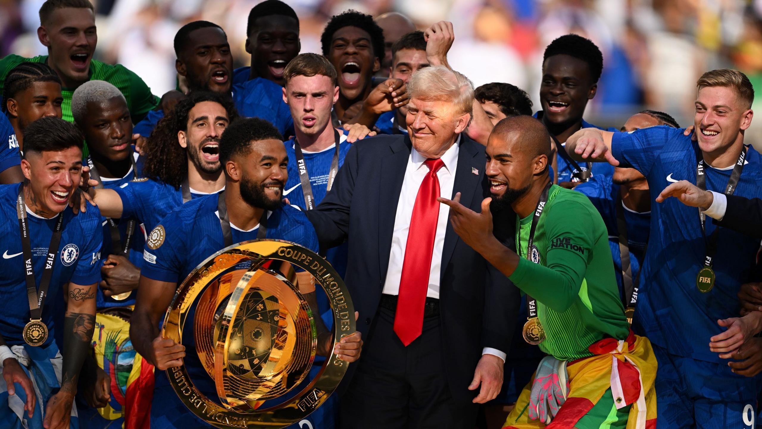 Donald Trump alongside Chelsea players preparing to lift the Club World Cup trophy