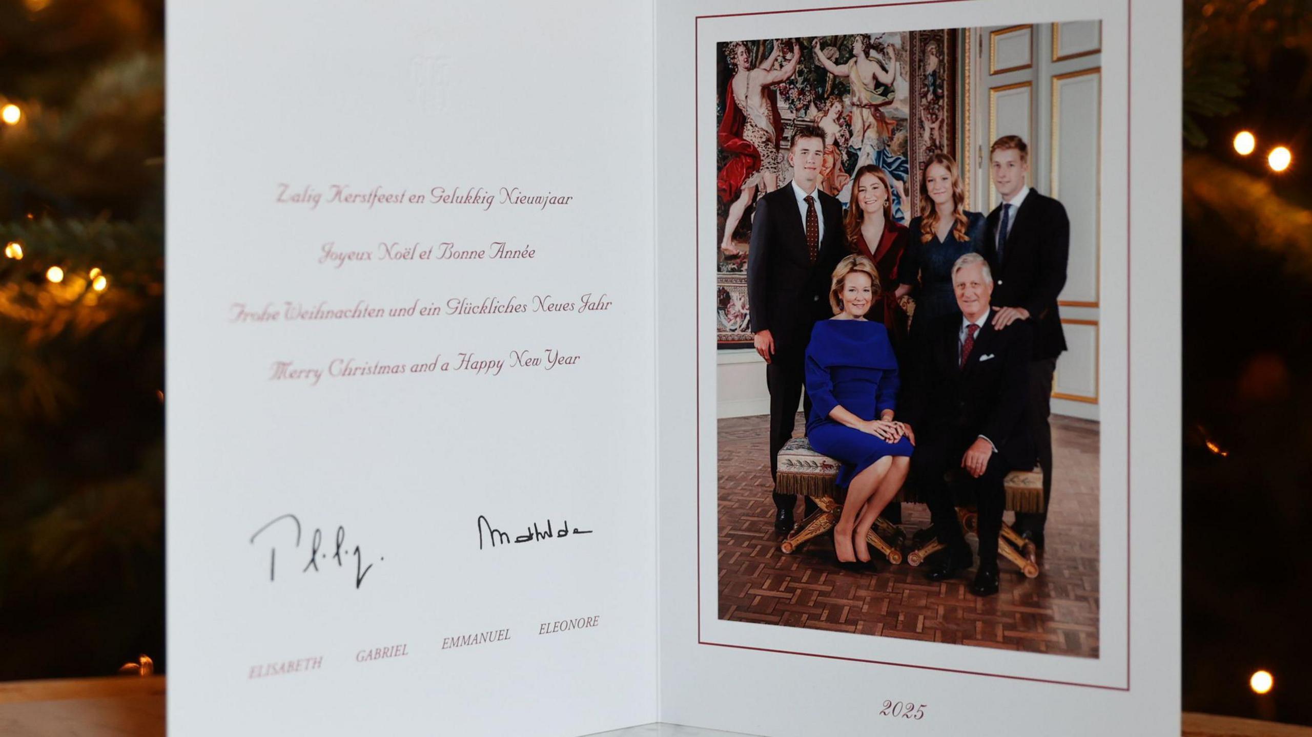 The Belgian royal family's Christmas card, dated 2025, features the family sitting and standing formally indoors, in front of a large painting. The message is in Dutch, French, Flemish and English and says: Merry Christmas and a Happy New Year. 