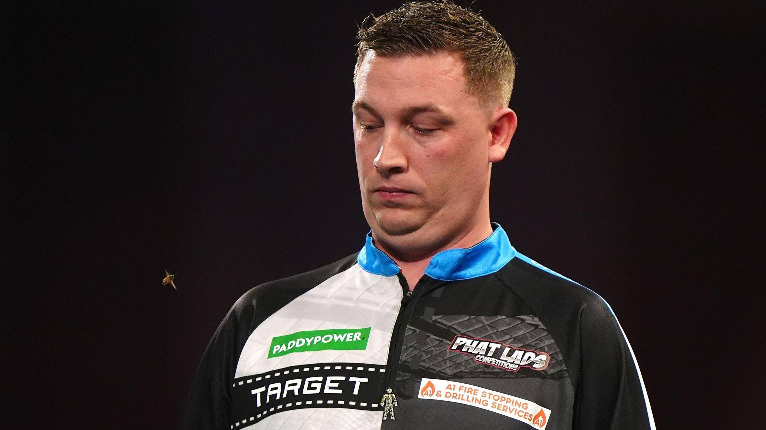 Chris Dobey tries to avoid a wasp at Alexandra Palace
