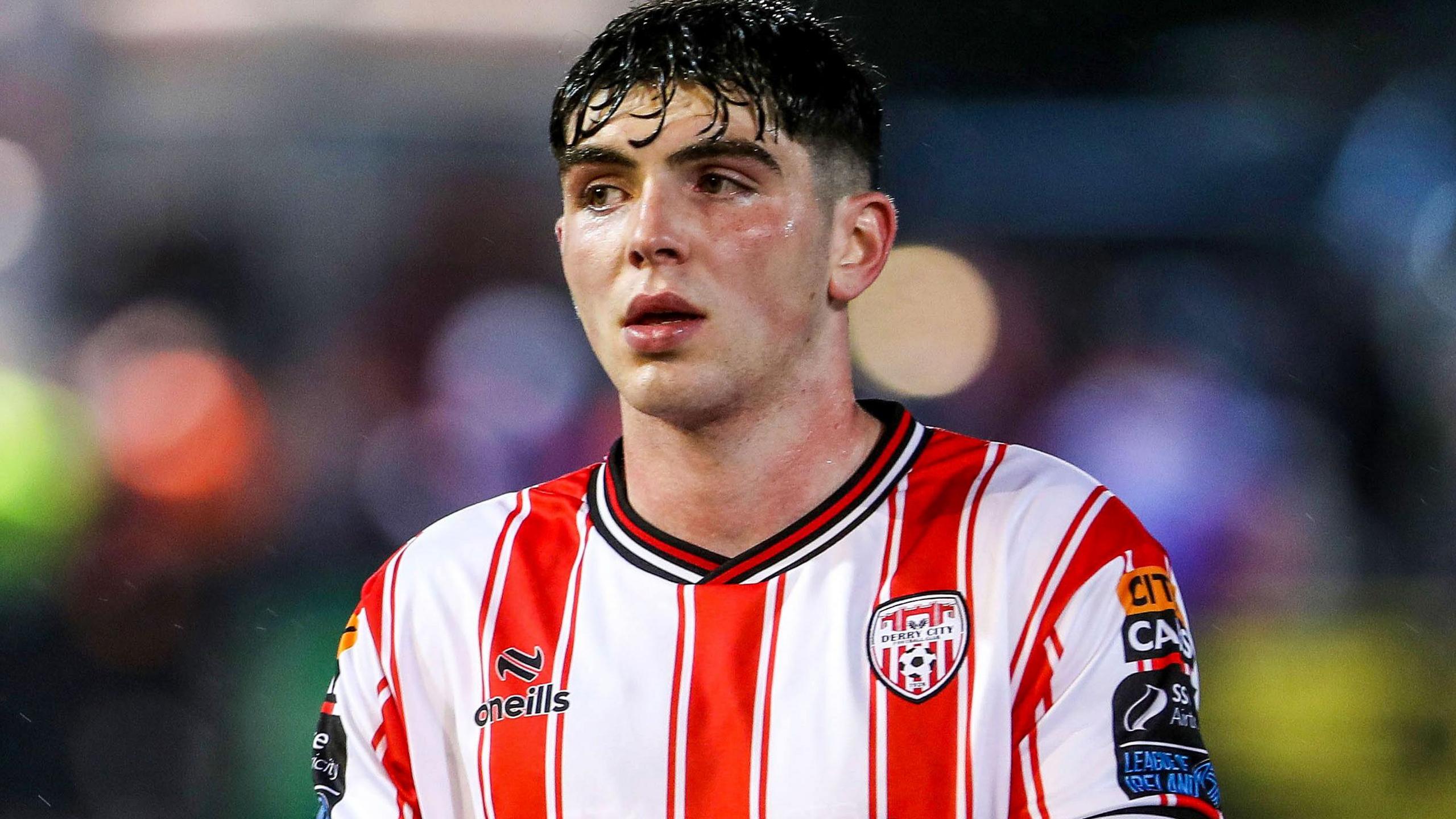 Sean Patton, wearing a red and white vertical striped shirt, in action for Derry City