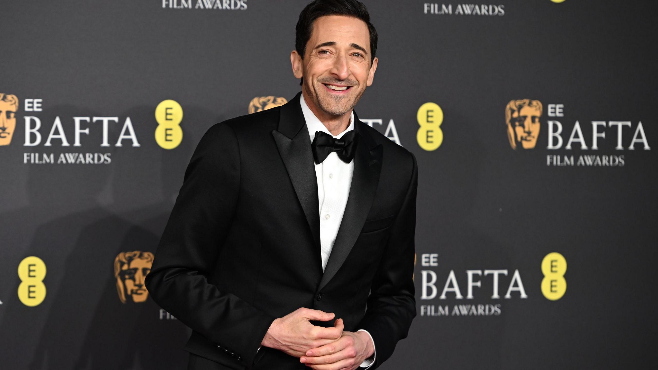 Adrien Brody in a black tuxedo and bow tie
