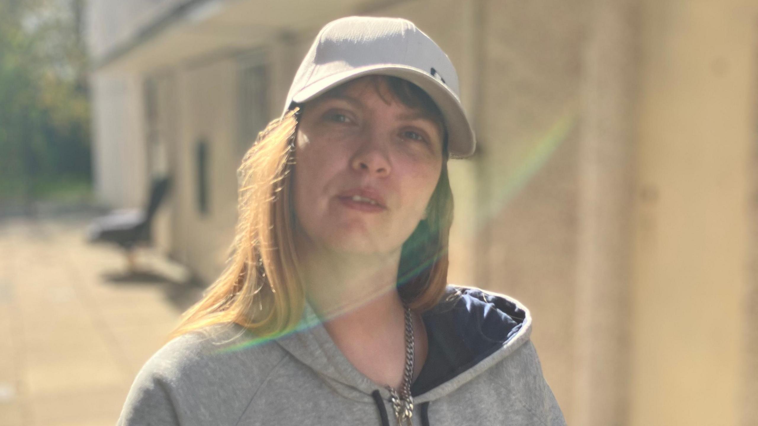 A woman in a white cap with long brown hair