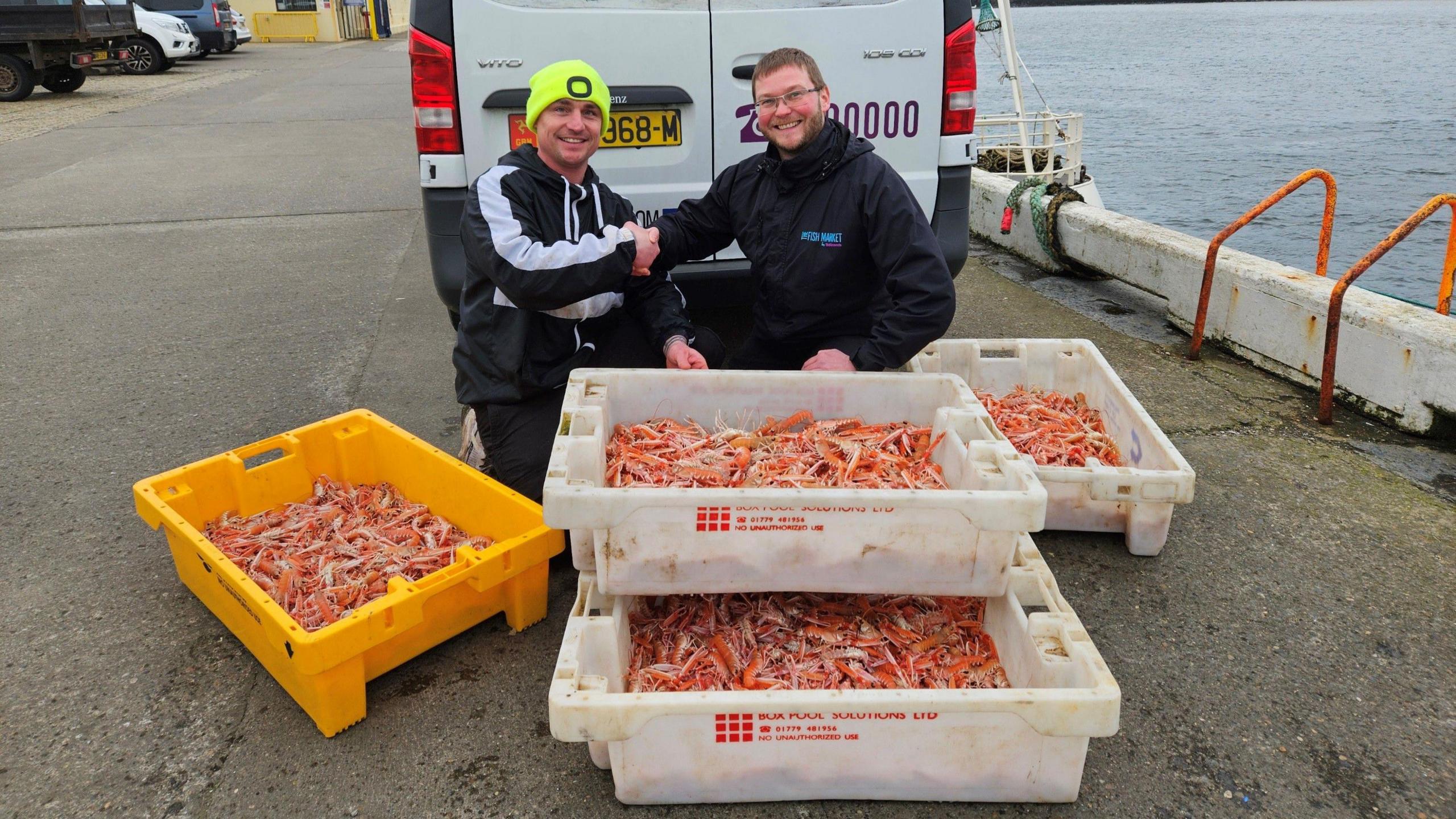 John Henley (skipper of New Dawn PL1) handing langoustines caught using creels to Jay Gore of Robinsons Fresh Foods IOM