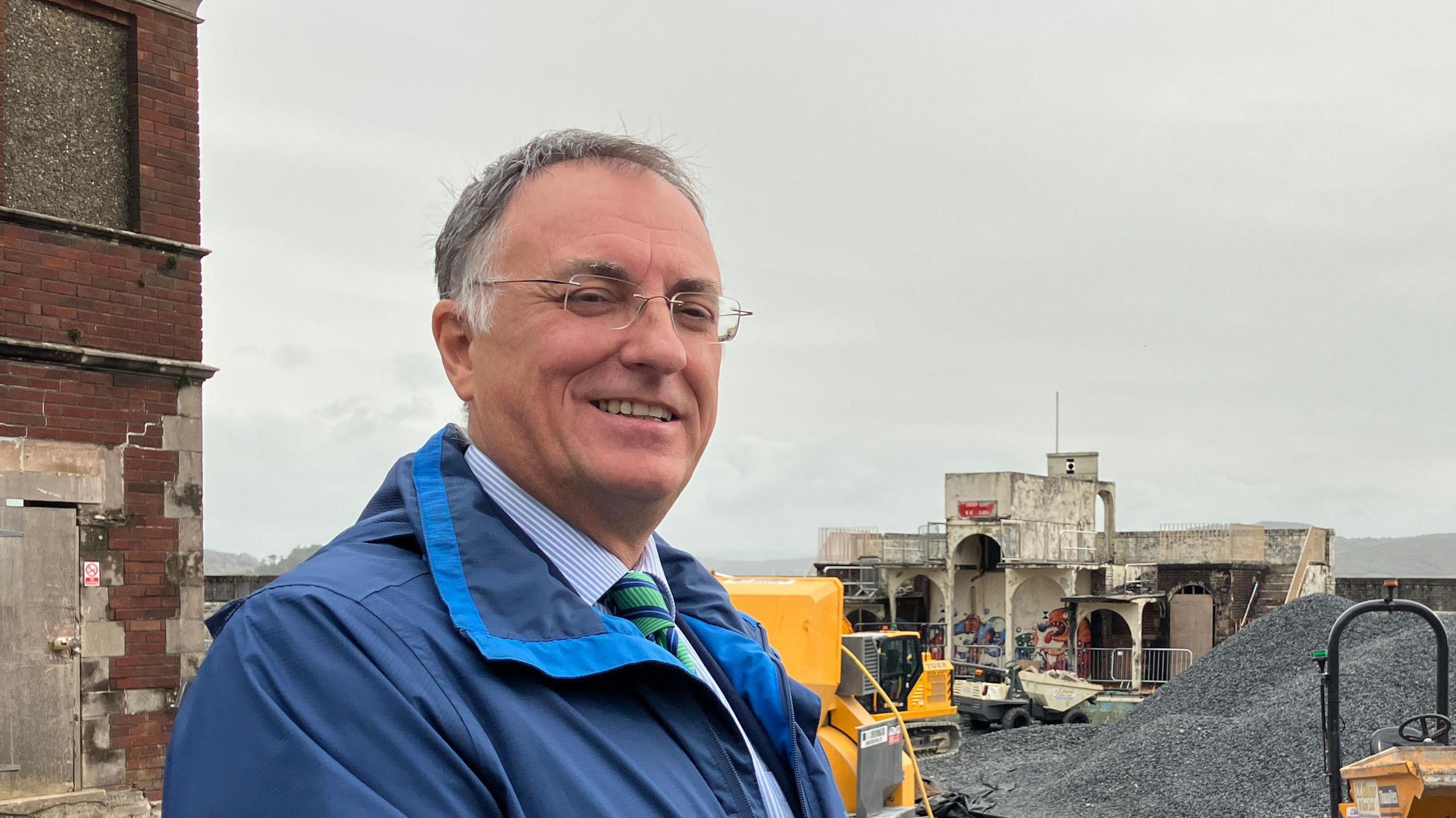 Westmorland and Furness Council leader Jonathan Brook standing in front of a building site.