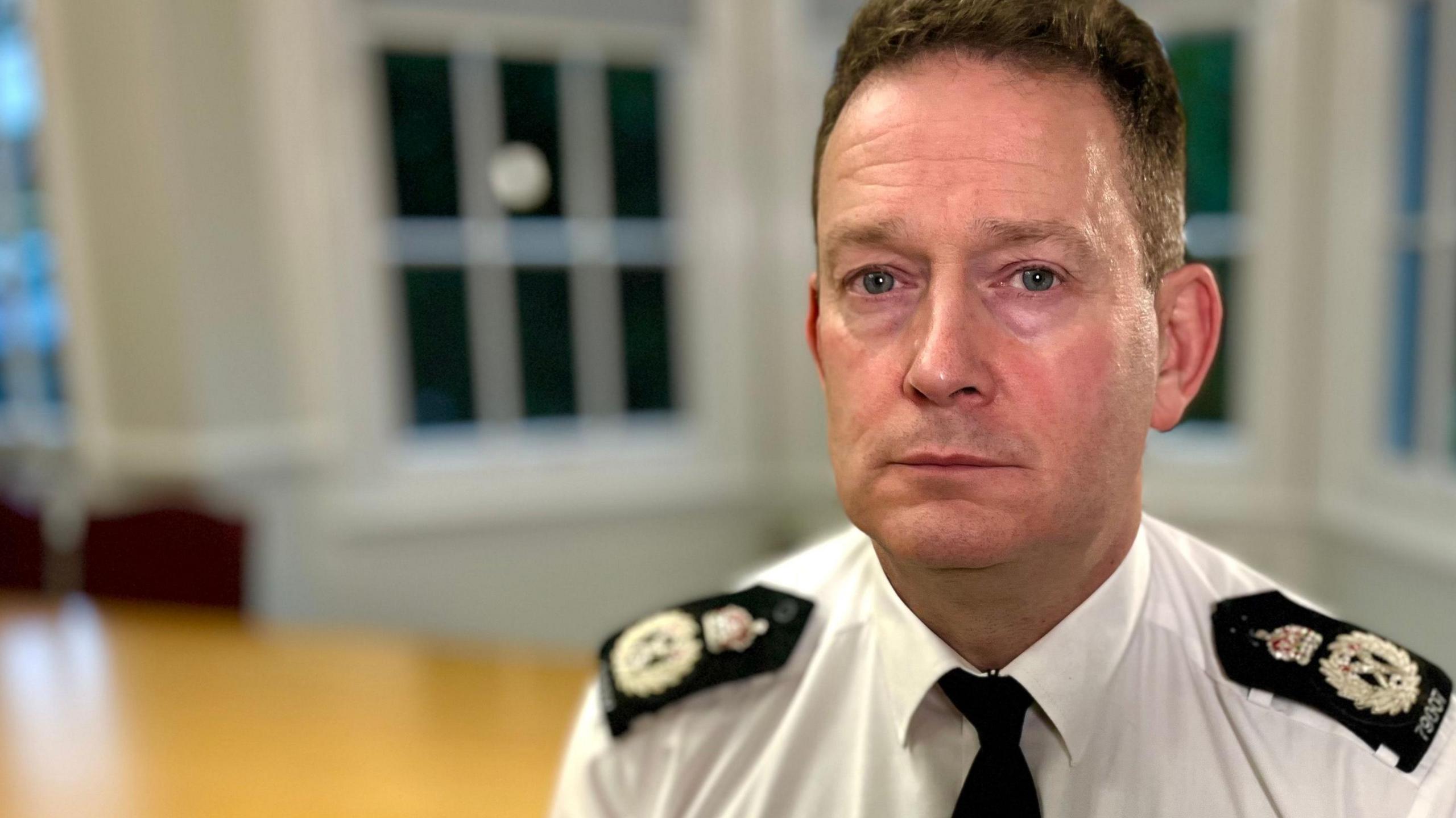 BJ Harrington, the Chief Constable of Essex Police, sitting in a room with a desk and bay windows behind him.