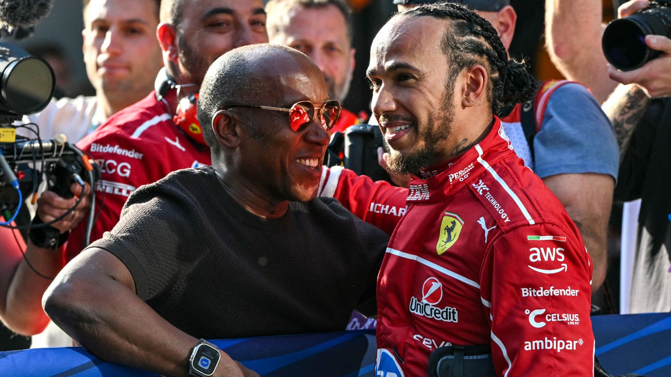 Lewis Hamilton of Ferrari speaks with his father, Anthony, in Parc ferme during the Chinese grand prix. 