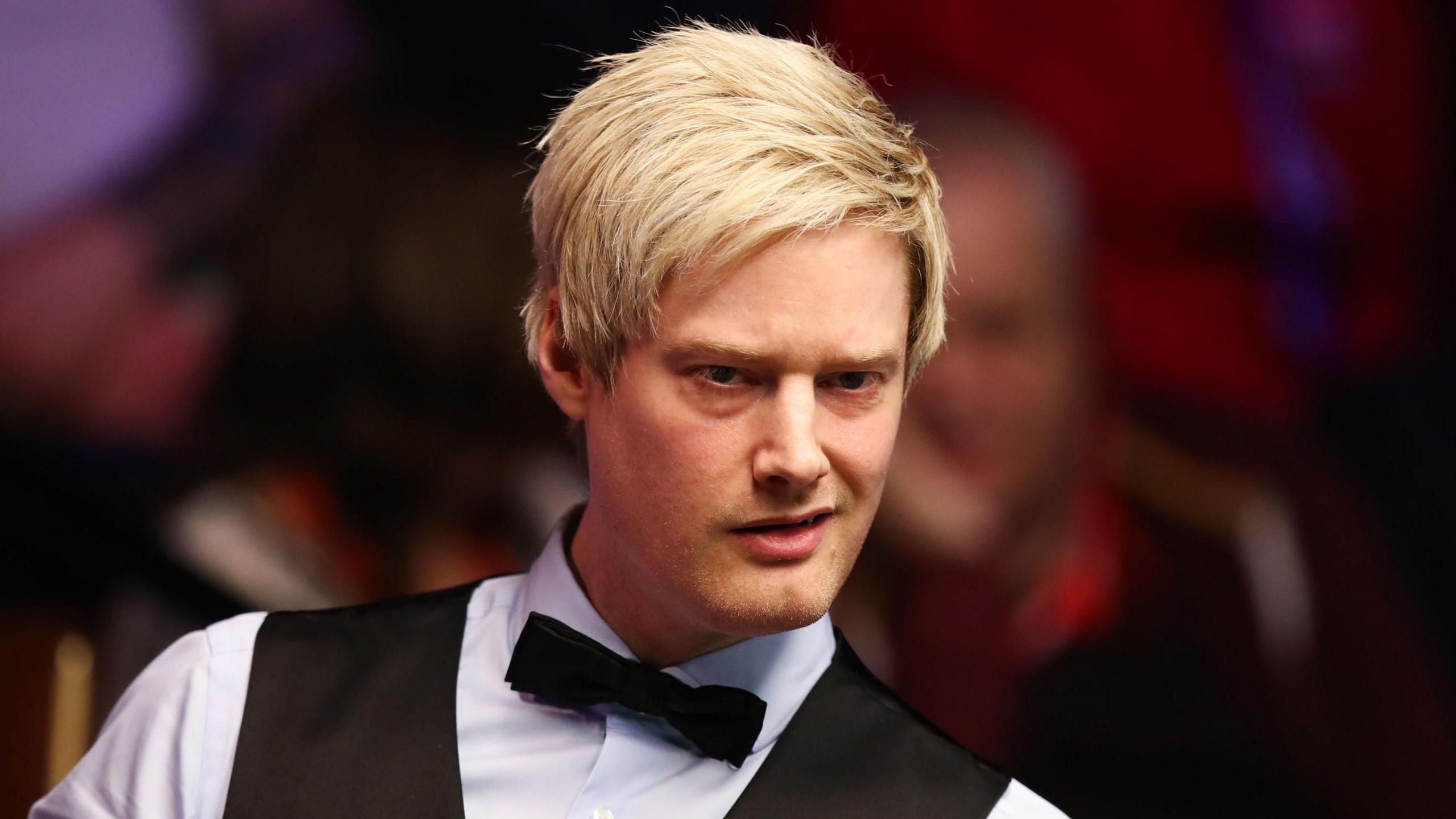 Robertson frowns slightly as he eyes up a shot. He is wearing a white shirt, black waistcoat and black bow tie.