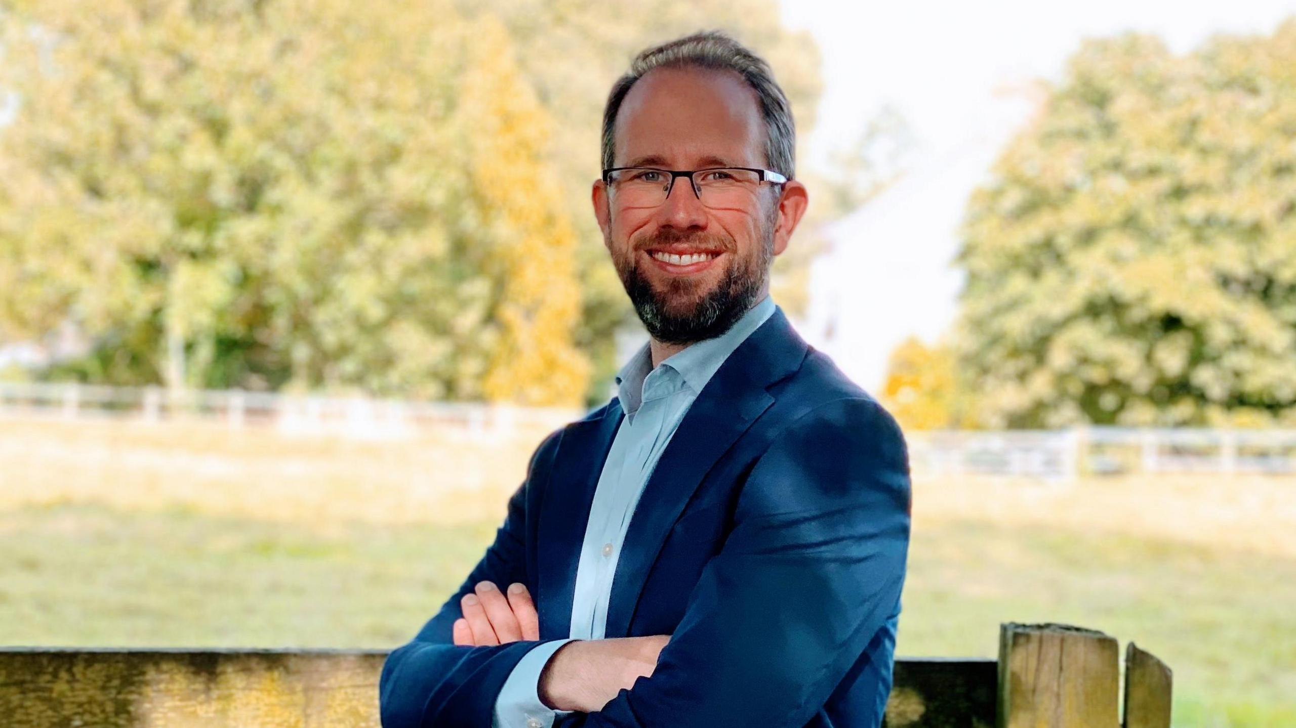 A picture of Thames Valley Police and Crime Commissioner Matthew Barber with a blue suit and jacket and a light blue shirt.