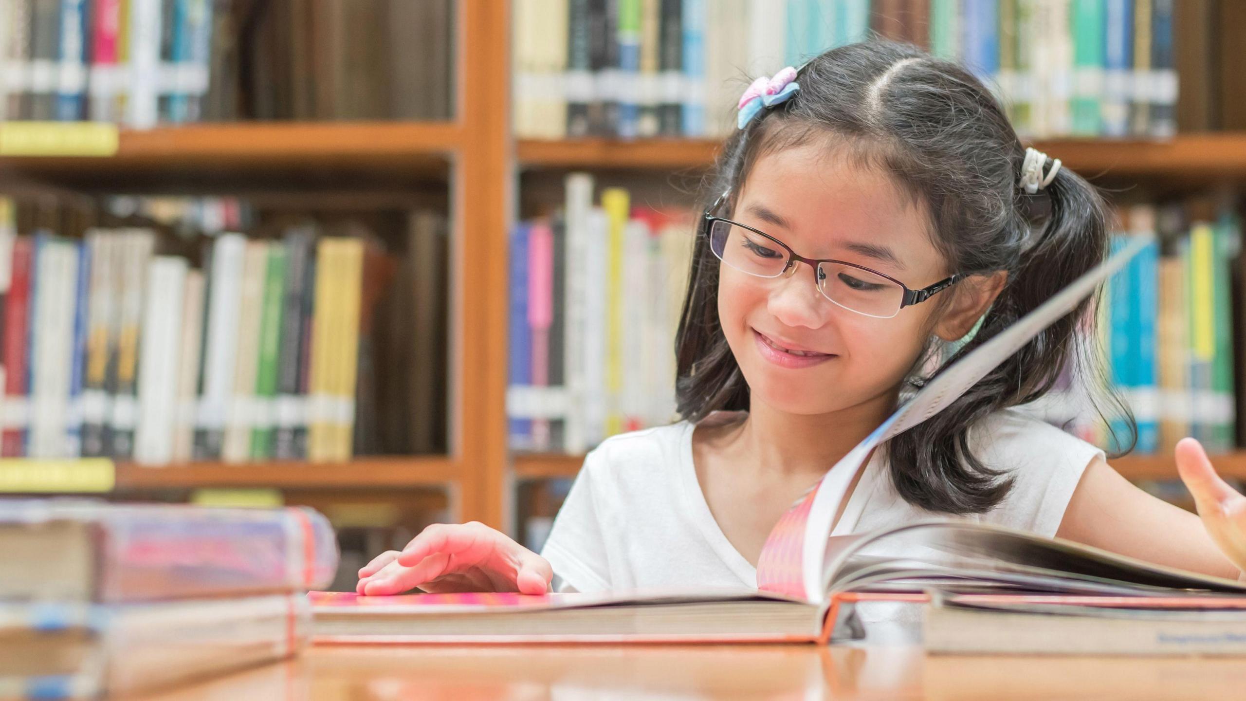 girl reading a book in a library