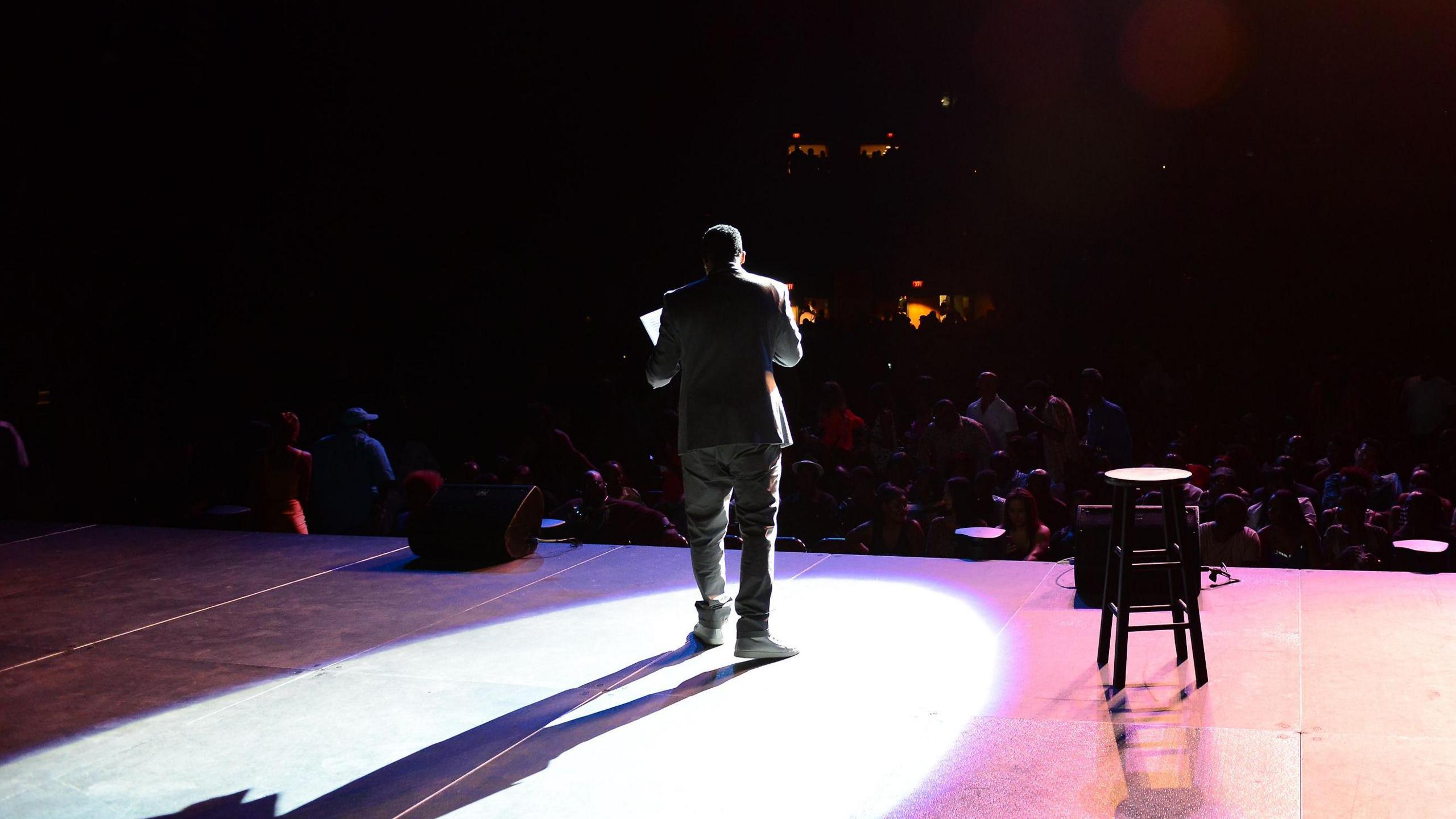 A man standing on his stager with a crowd in front of him