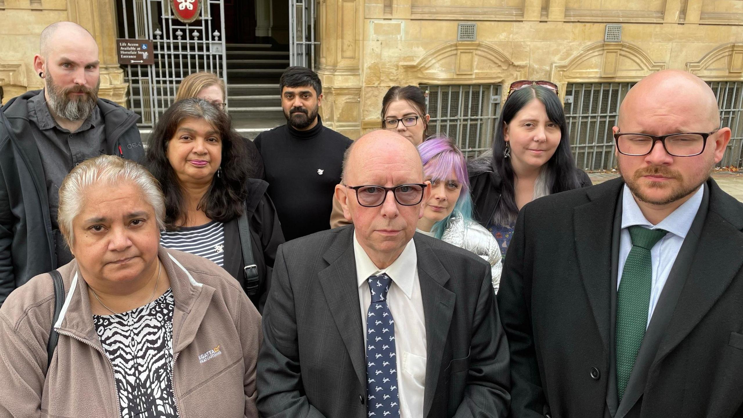 A group of people gathered outside of Leicester Town Hall