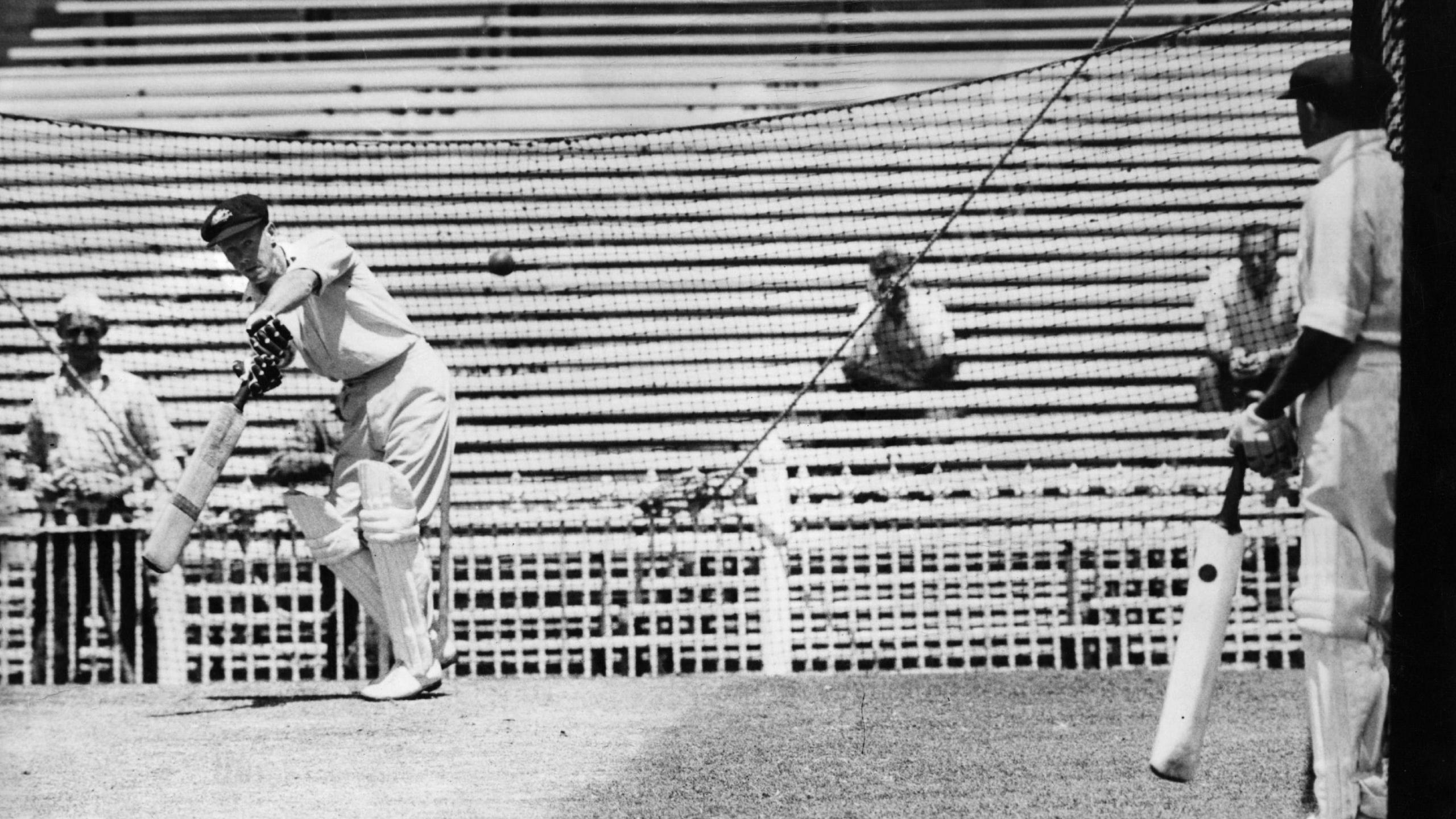 Australian cricketer Don Bradman (1908 - 2001) gives a batting lesson to Bill Brown before the fifth Test against India. (Photo by Keystone/Getty Images)
