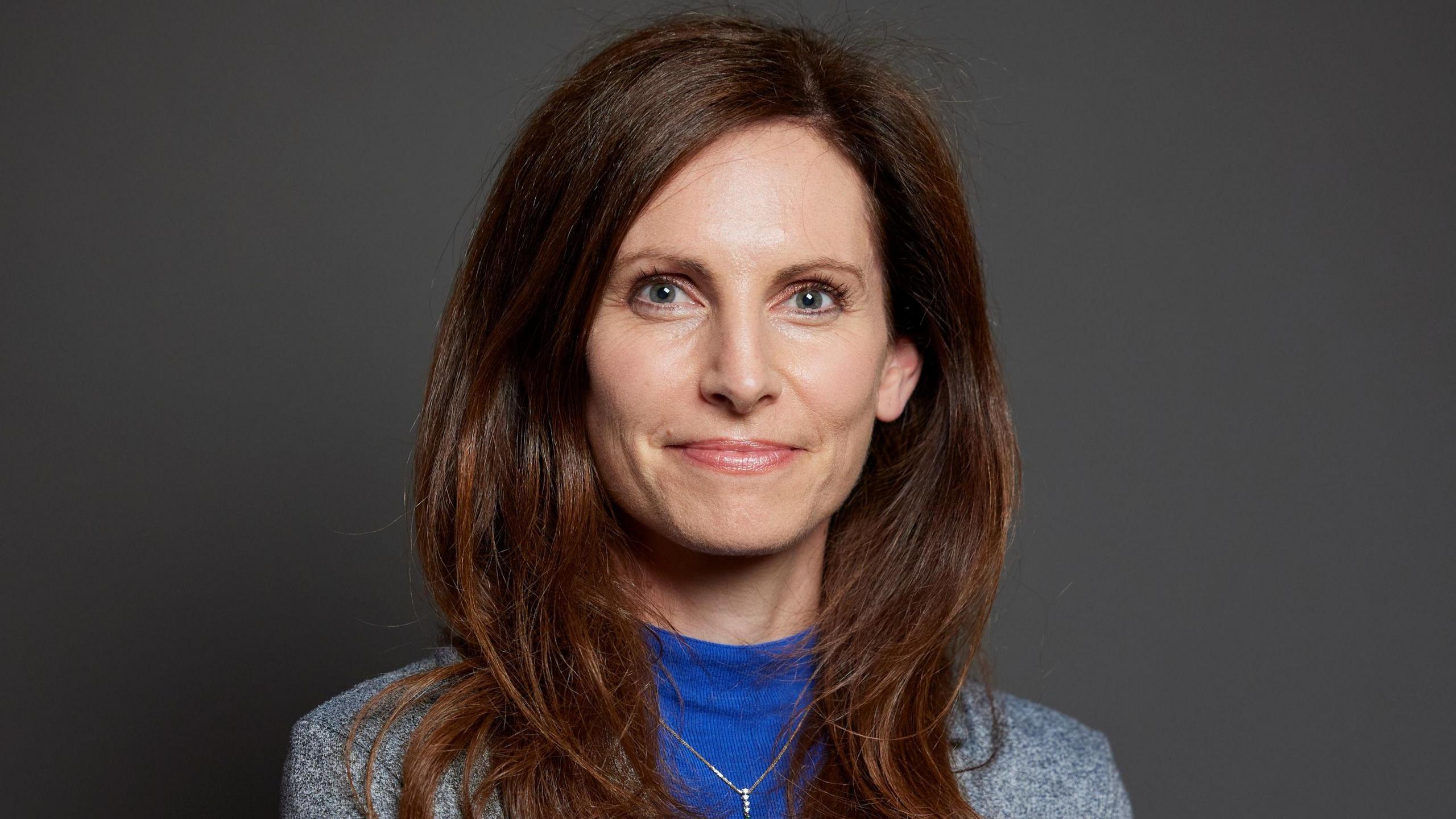 Parliament portrait of Chester South and Eddisbury MP, Conservative Aphra Brandreth. She has long brown hair and is wearing a blue top and grey jacket.