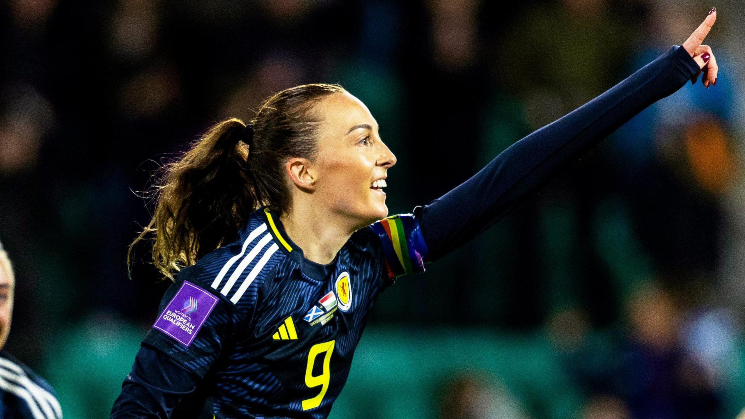 Caroline Weir celebrating in Scotland shirt as she points upwards with her left hand