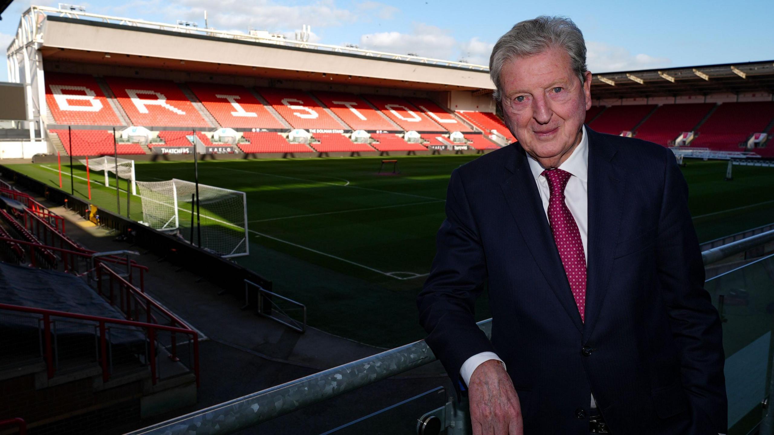 Roy Hodgson standing with a view inside Ashton Gate Stadium behind him and the word BRISTOL displayed on the stand seats 