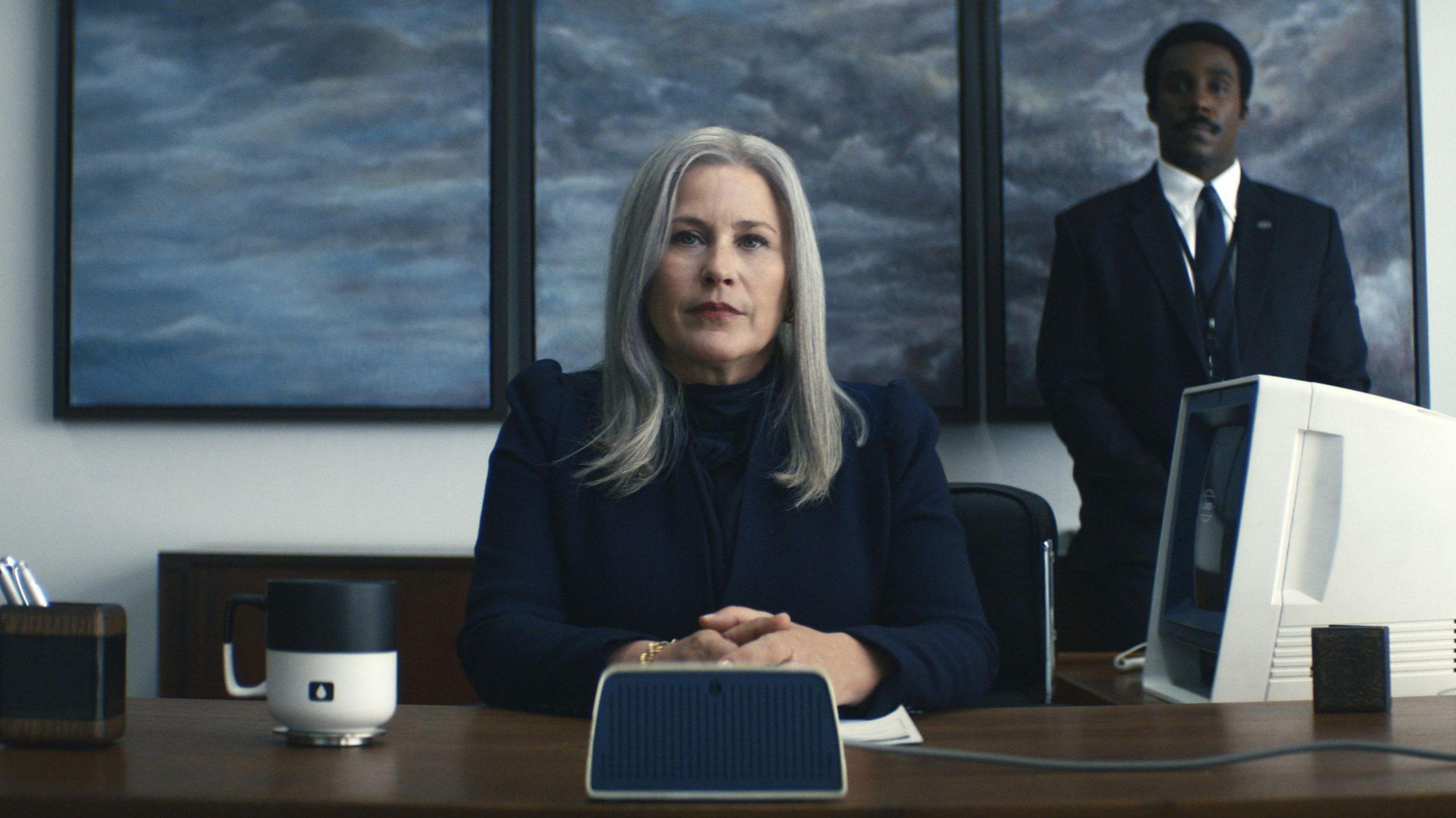 Patricia Arquette as Harmony Cobel, sitting in the the floor manager's office