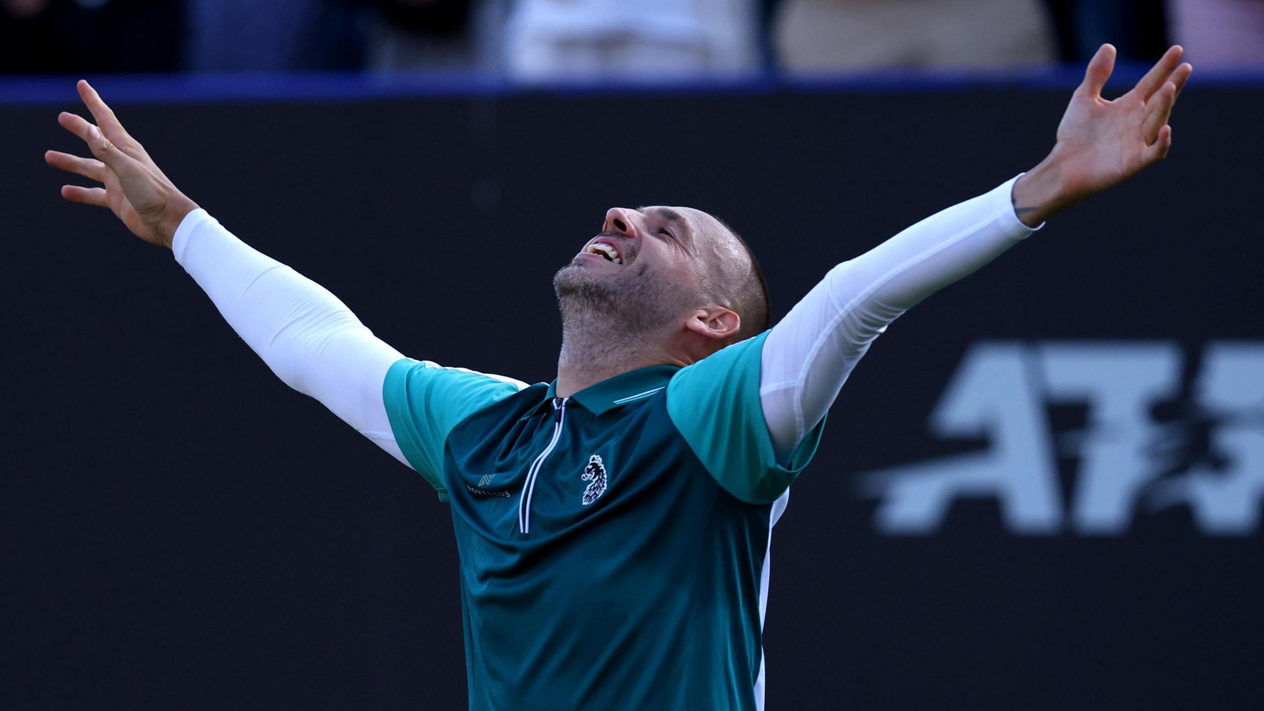 Dan Evans celebrates with arms outstretched