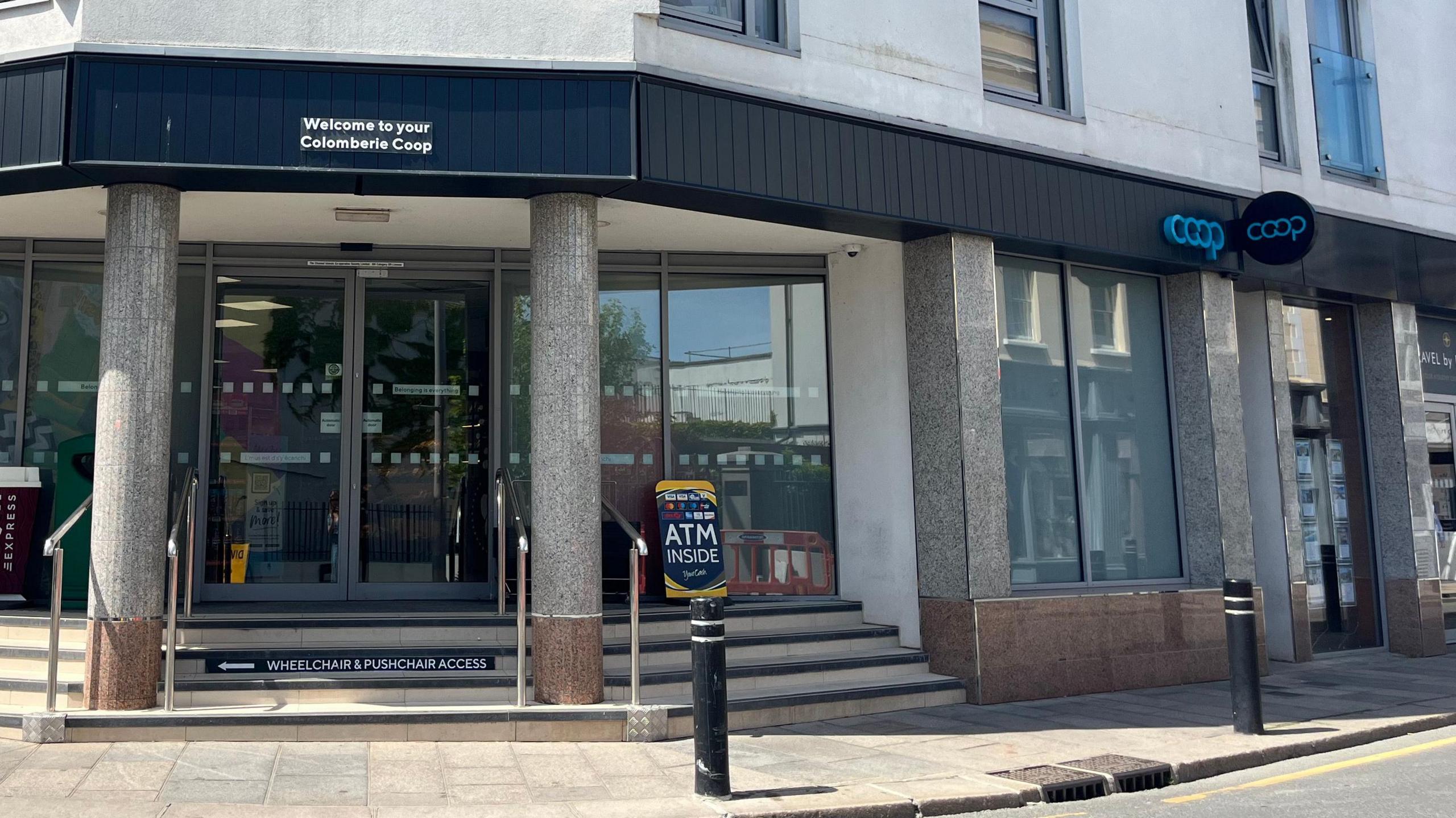 A wide shot of the co-operative. It is fronted by two grey pillars, and has a dark coloured sign.